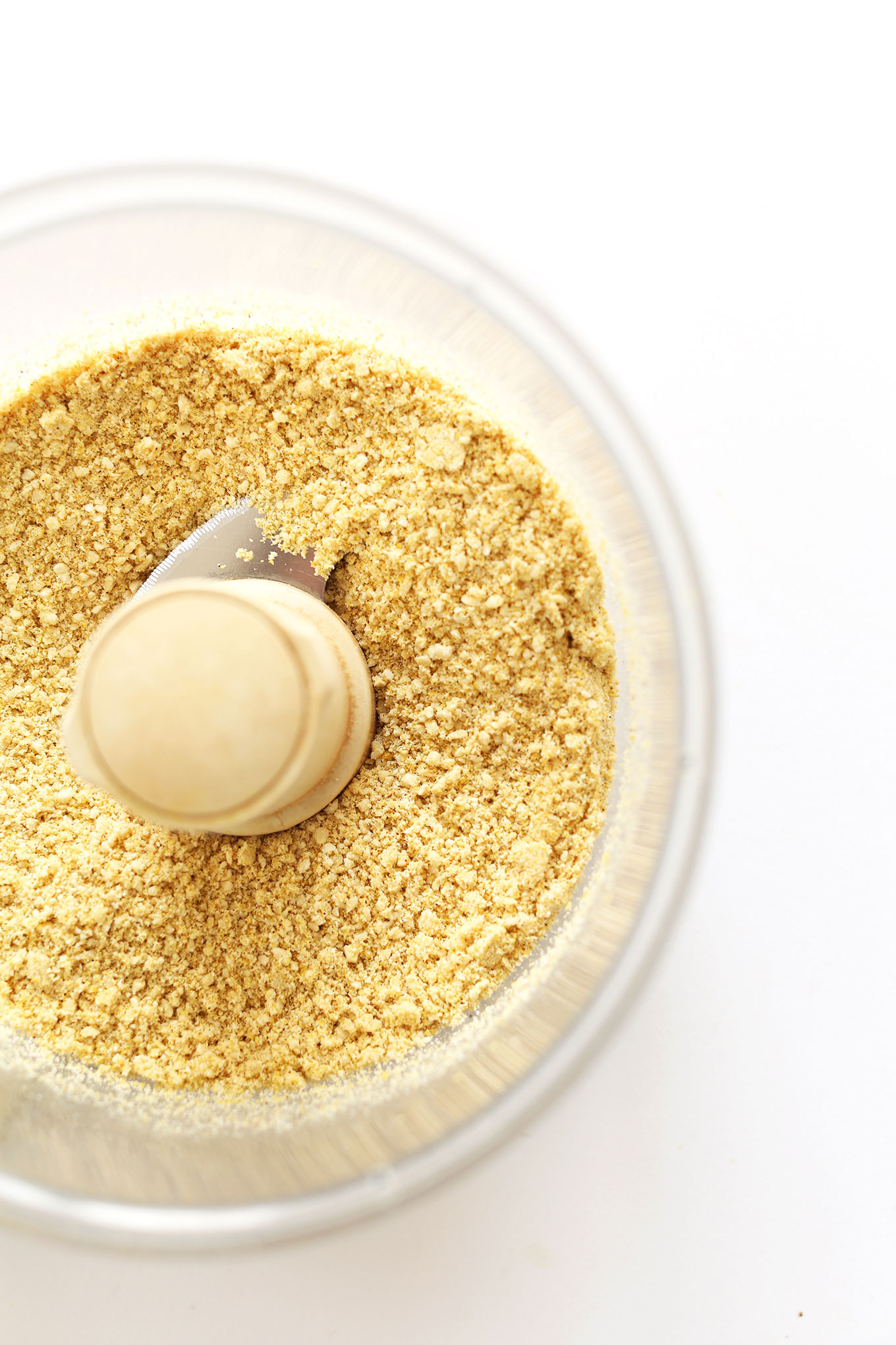 Food processor with freshly pulsed cashews and other ingredients for Shakeable Mexican Cheese