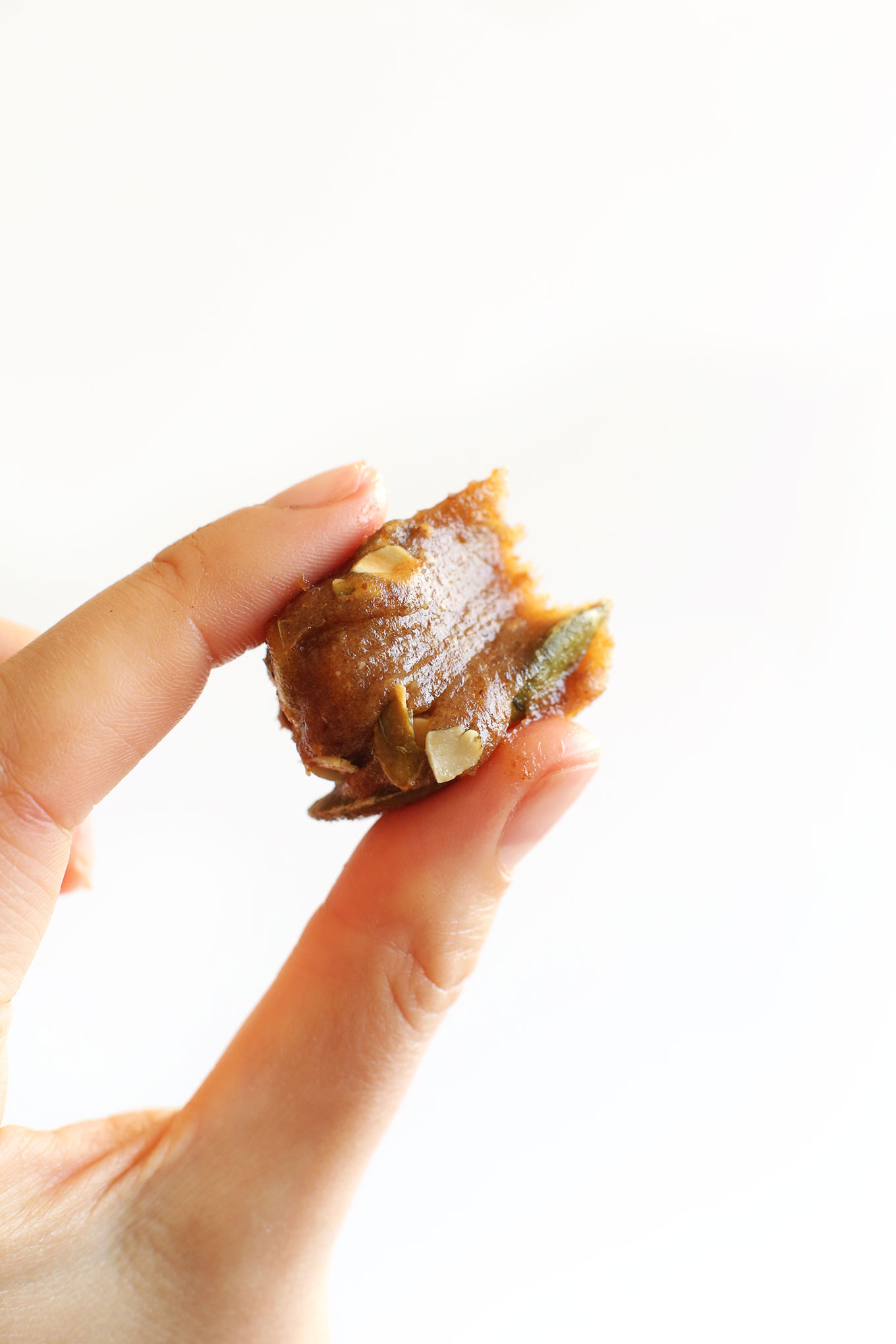 Holding up a partially eaten vegan Pumpkin Caramel