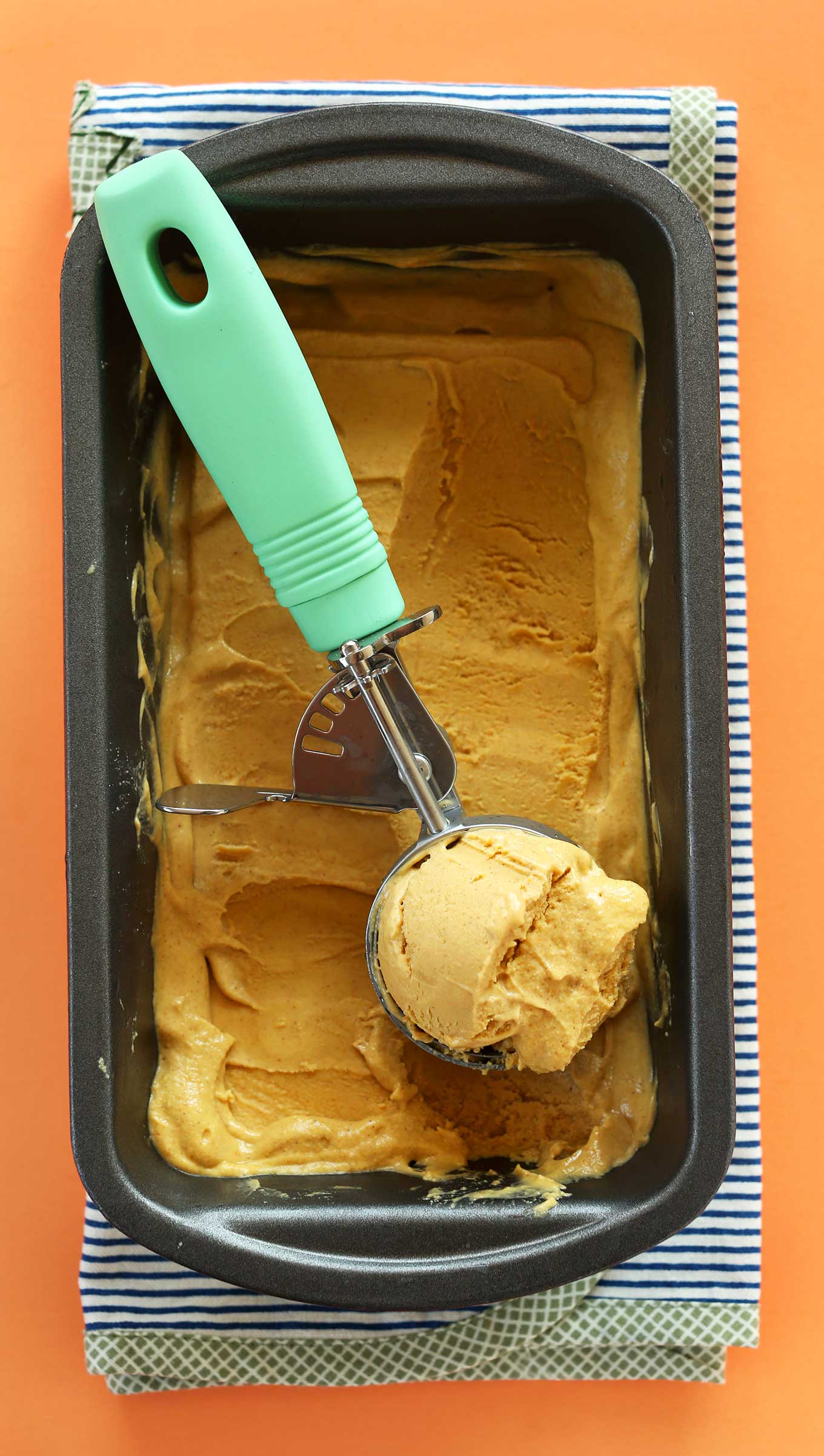 Using an ice cream scooper to grab a scoop of creamy vegan Pumpkin Pie Ice Cream