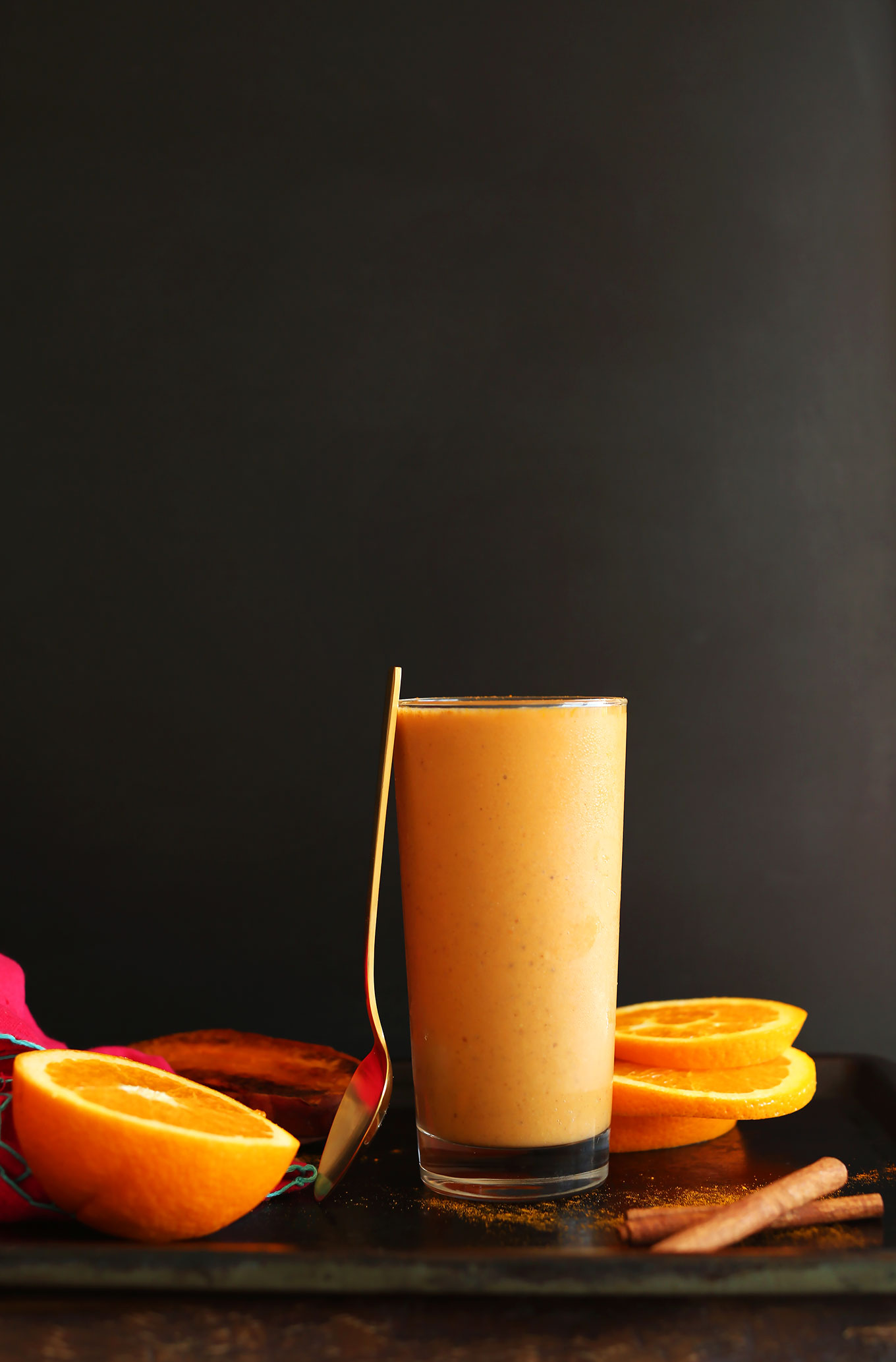 Spoon resting on a glass filled with our Creamy Sweet Potato Smoothie recipe