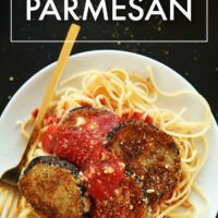 Plate of vegan eggplant parmesan over spaghetti noodles