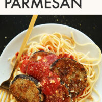Plate of vegan eggplant parmesan over spaghetti noodles