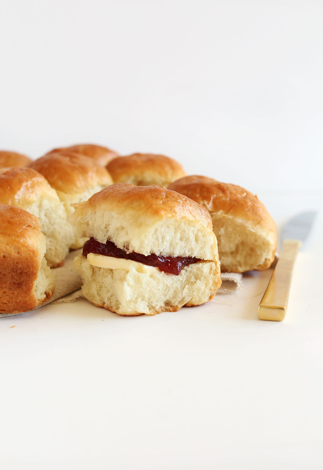 Freshly baked vegan dinner rolls filled with jam and vegan butter