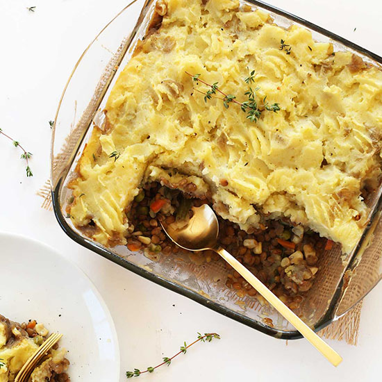 Glass baking dish of Vegan Shepherds Pie with a couple servings removed