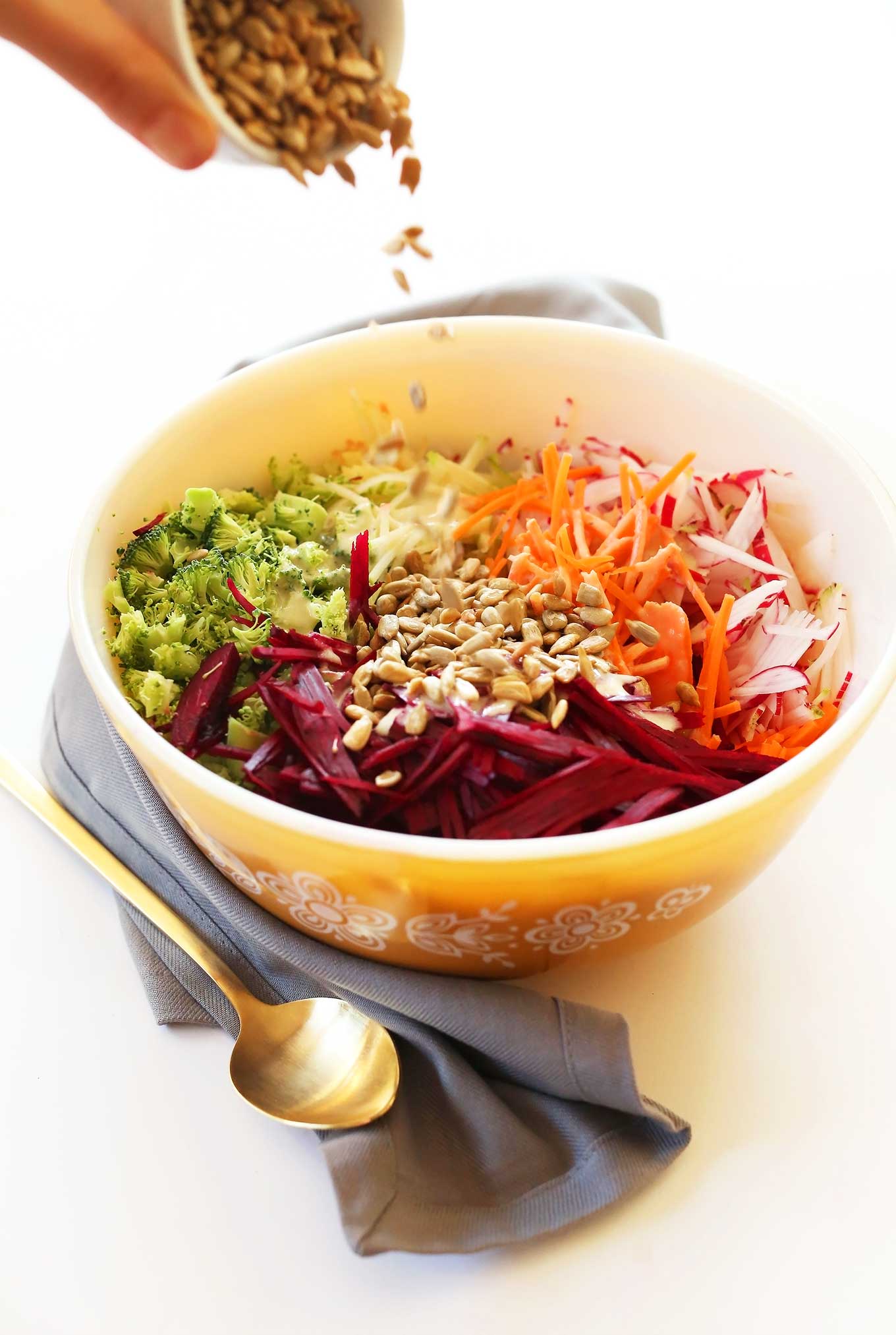 Sprinkling sunflower seeds onto our healthy fall slaw for a Thanksgiving salad