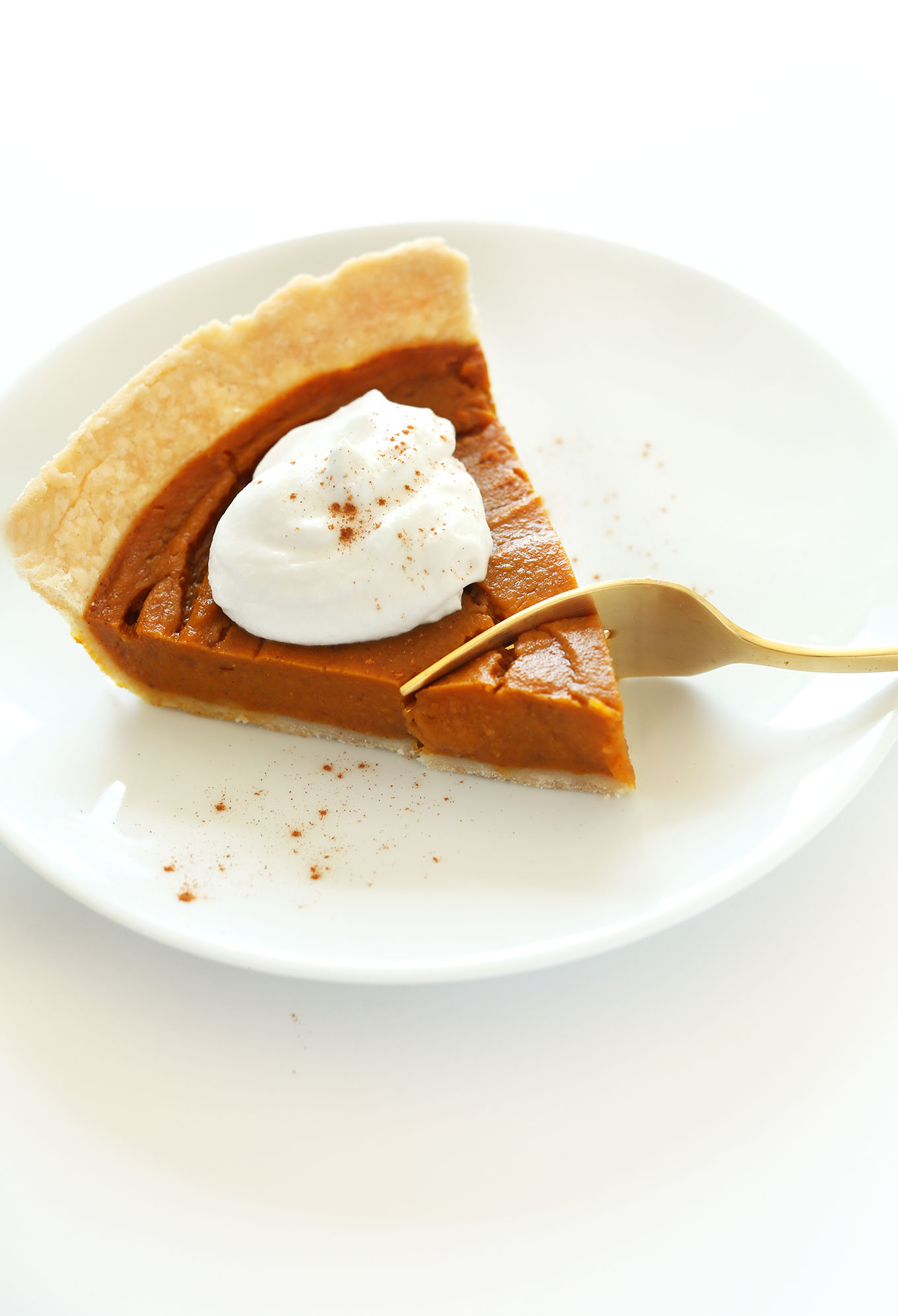 Grabbing a bite from the tip of a slice of vegan gluten-free pumpkin pie