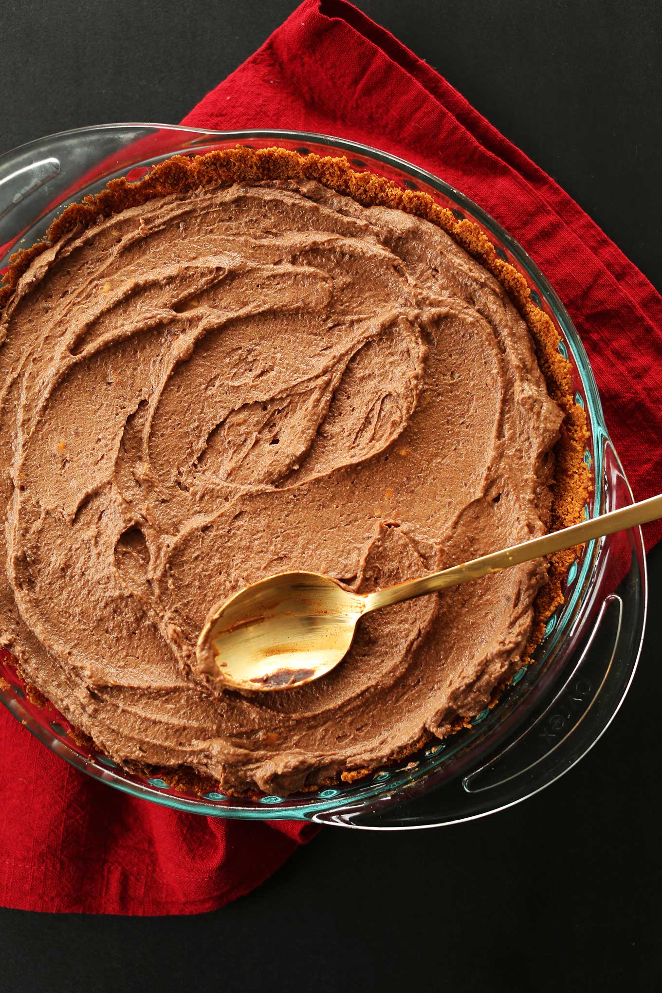 Spreading Vegan Chocolate Peanut Butter Mousse into a pie pan for a delicious vegan dessert