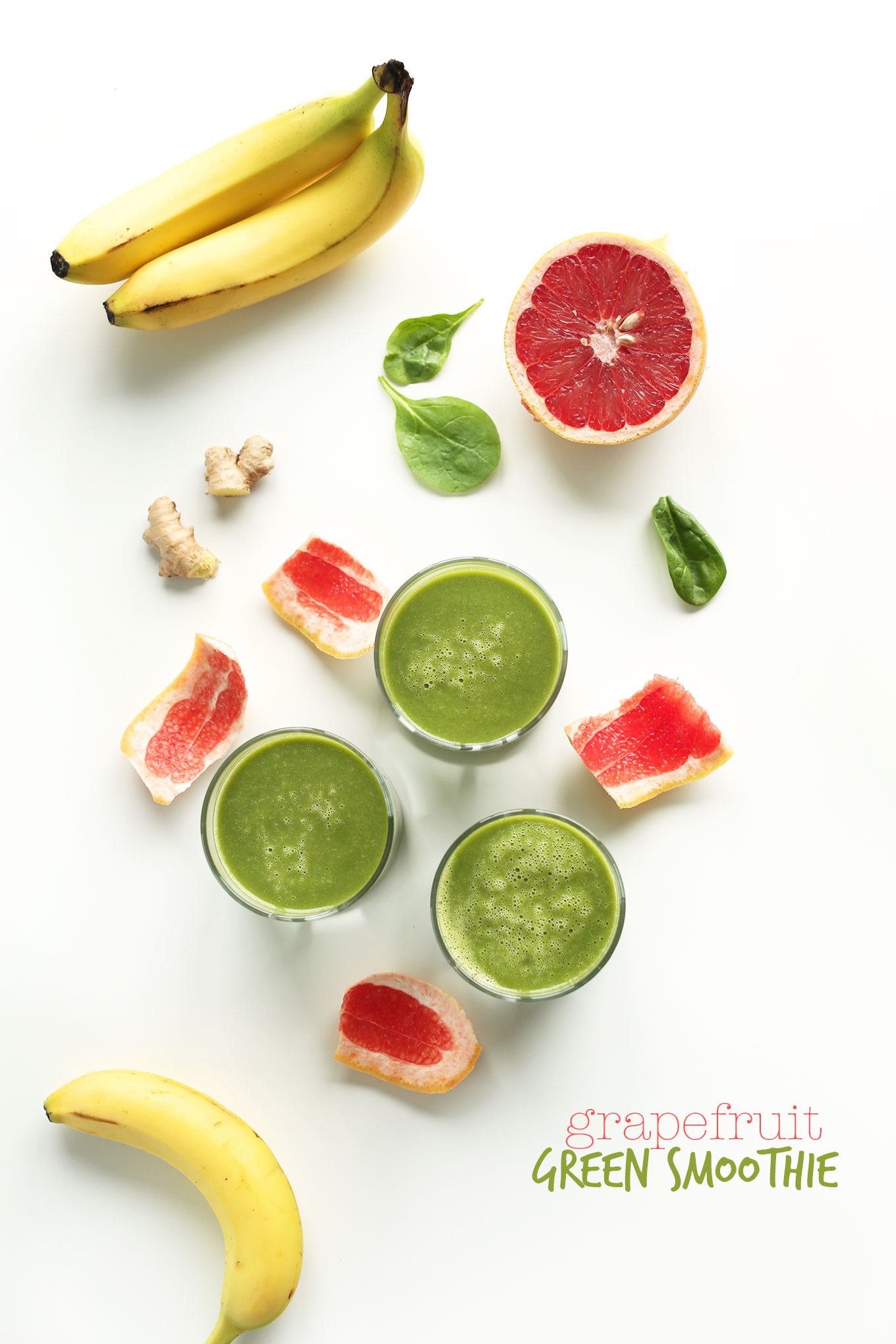 Grapefruit Green Smoothies surrounded by ginger, spinach, bananas, and grapefruit