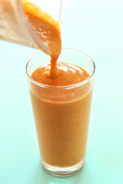 Pouring a tall glass of our vibrant Orange Sweet Potato Smoothie