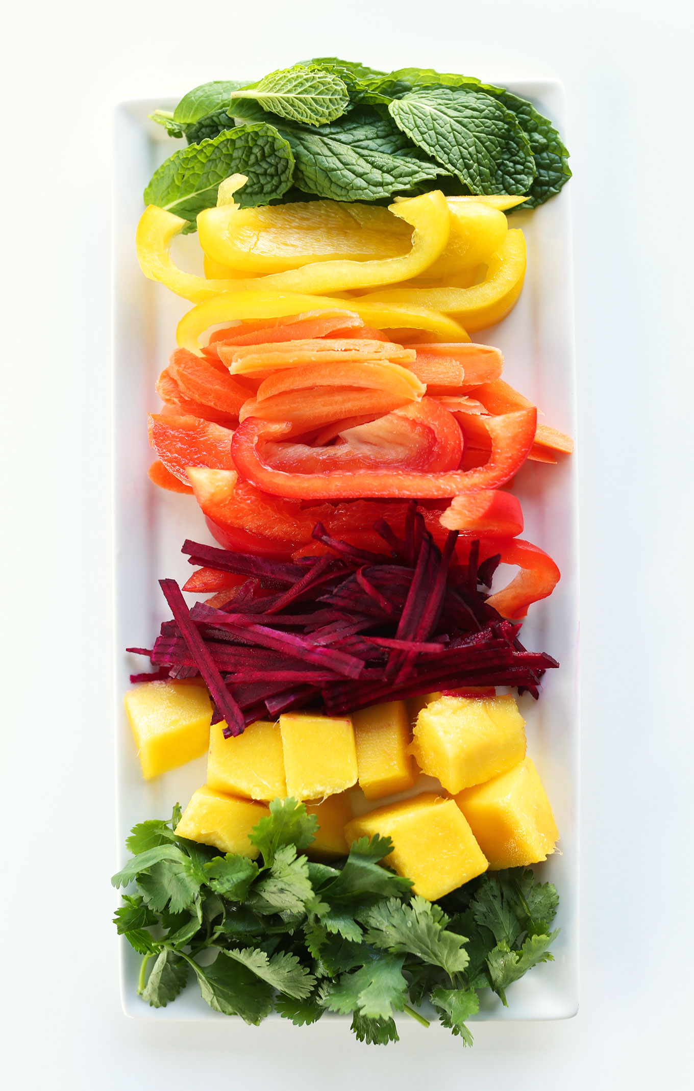 Freshly sliced vegetables and mango for making Rainbow Spring Rolls