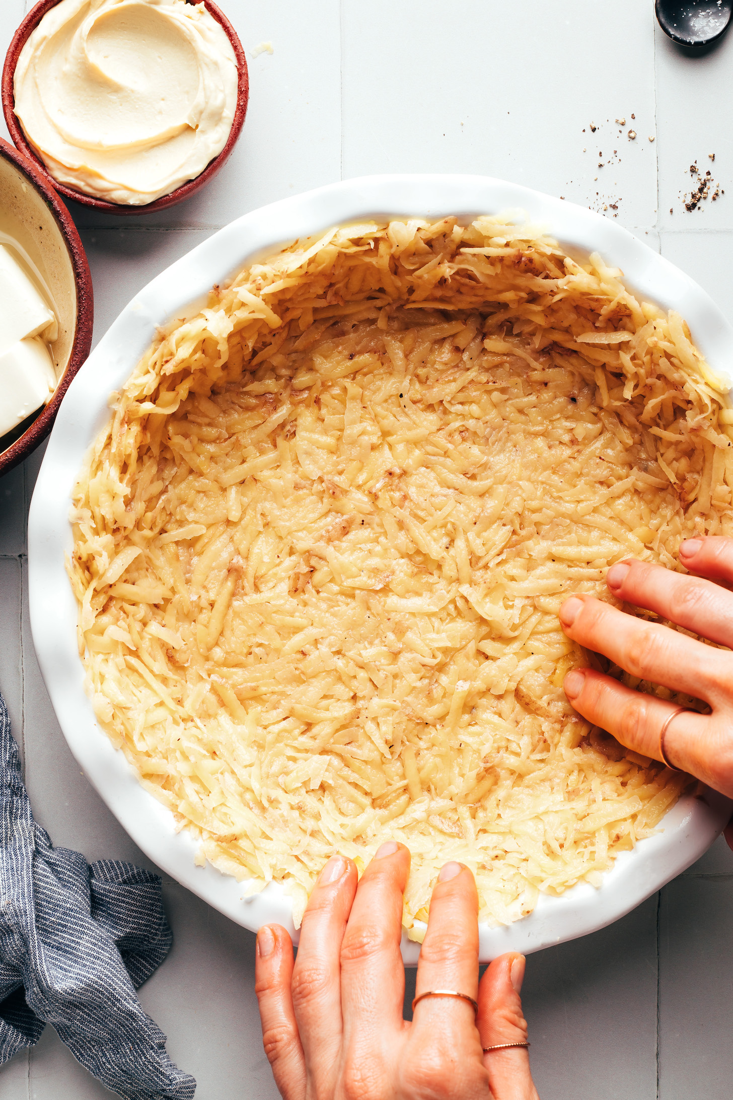 Pressing a hashbrown crust into a pie pan