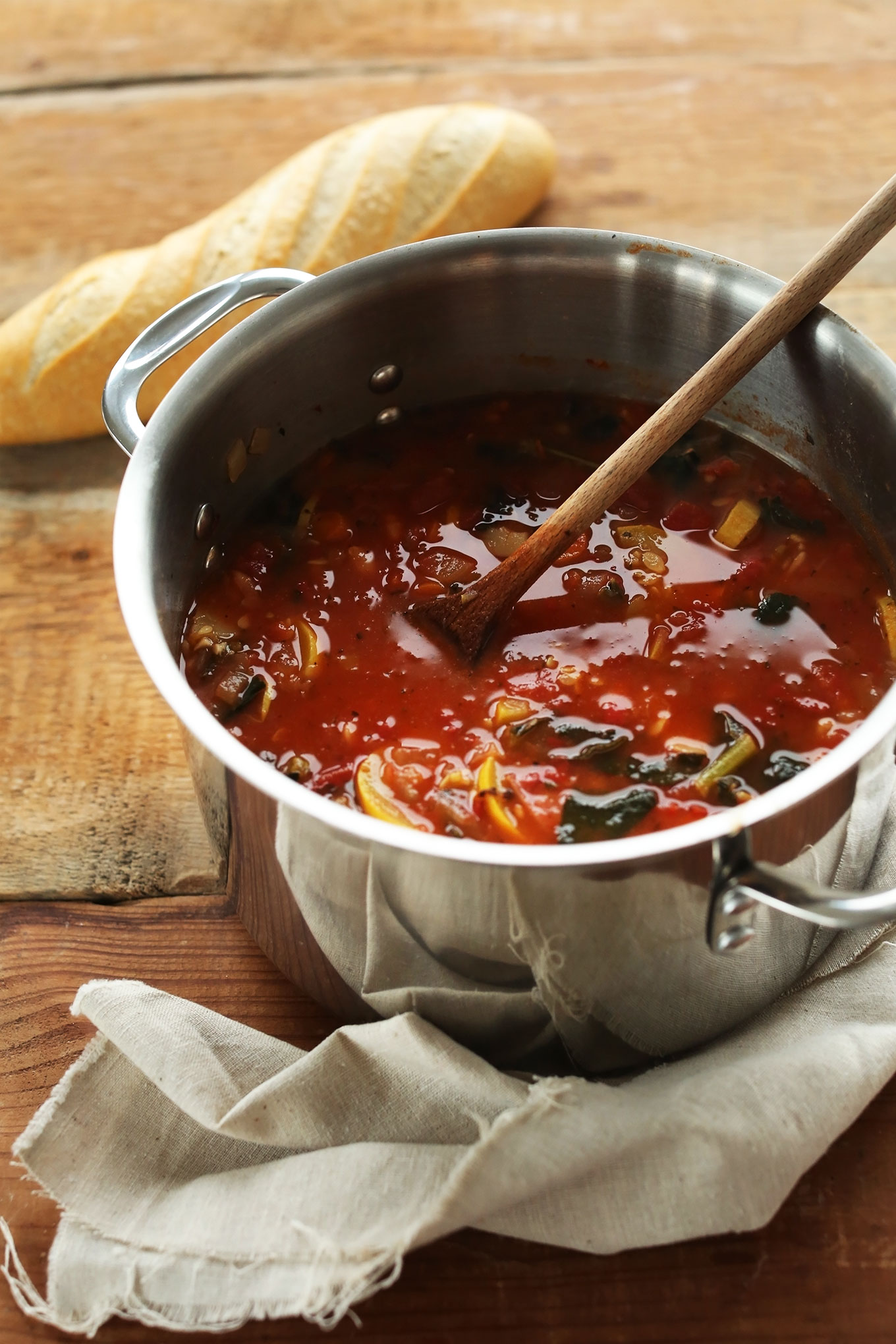 Stirring a big pot of gluten-free Veggie and White Bean Stew