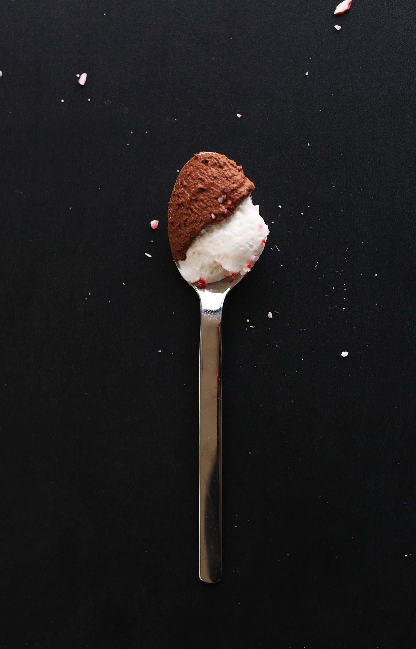 Spoonful of homemade Dark Chocolate Peppermint Mousse topped with coconut whipped cream