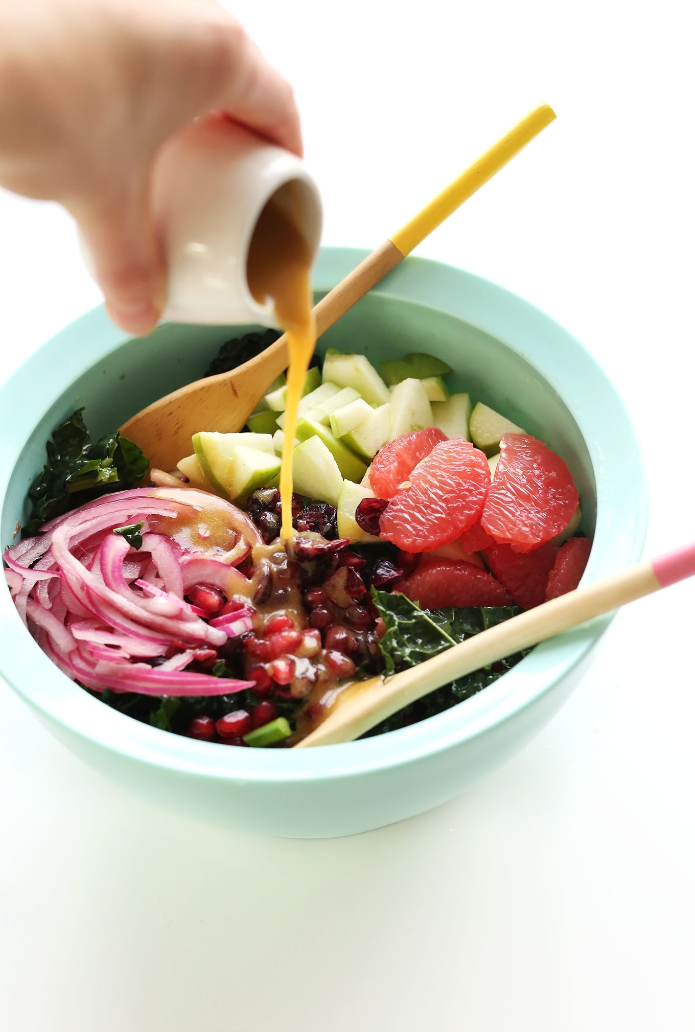 Pouring a simple red wine vinaigrette onto our healthy Citrus Kale Salad