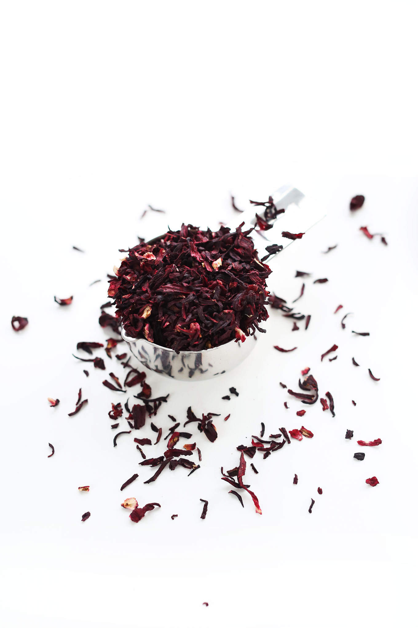 Measuring cup filled with loose-leaf hibiscus for making homemade margaritas