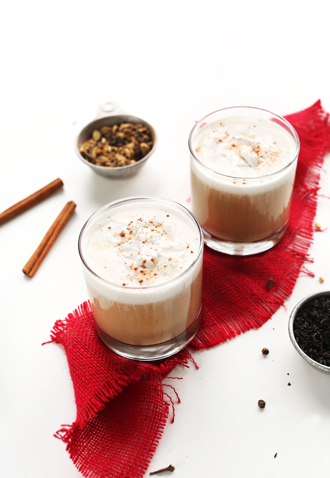 Glasses filled with our Creamy Vegan Chai Latte with coconut whip