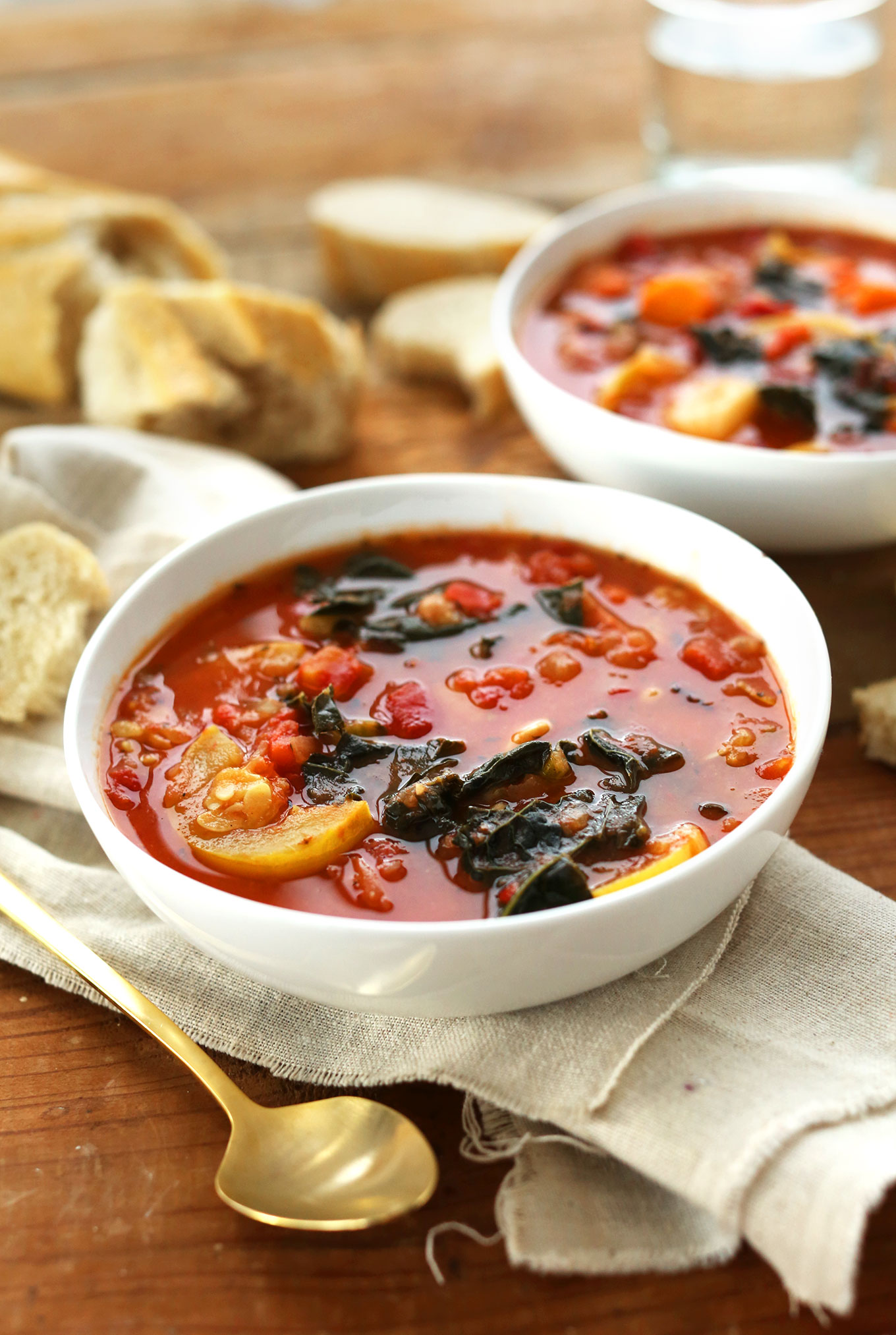 Bowl of Vegan White Bean Stew loaded with potatoes, kale, and tomatoes