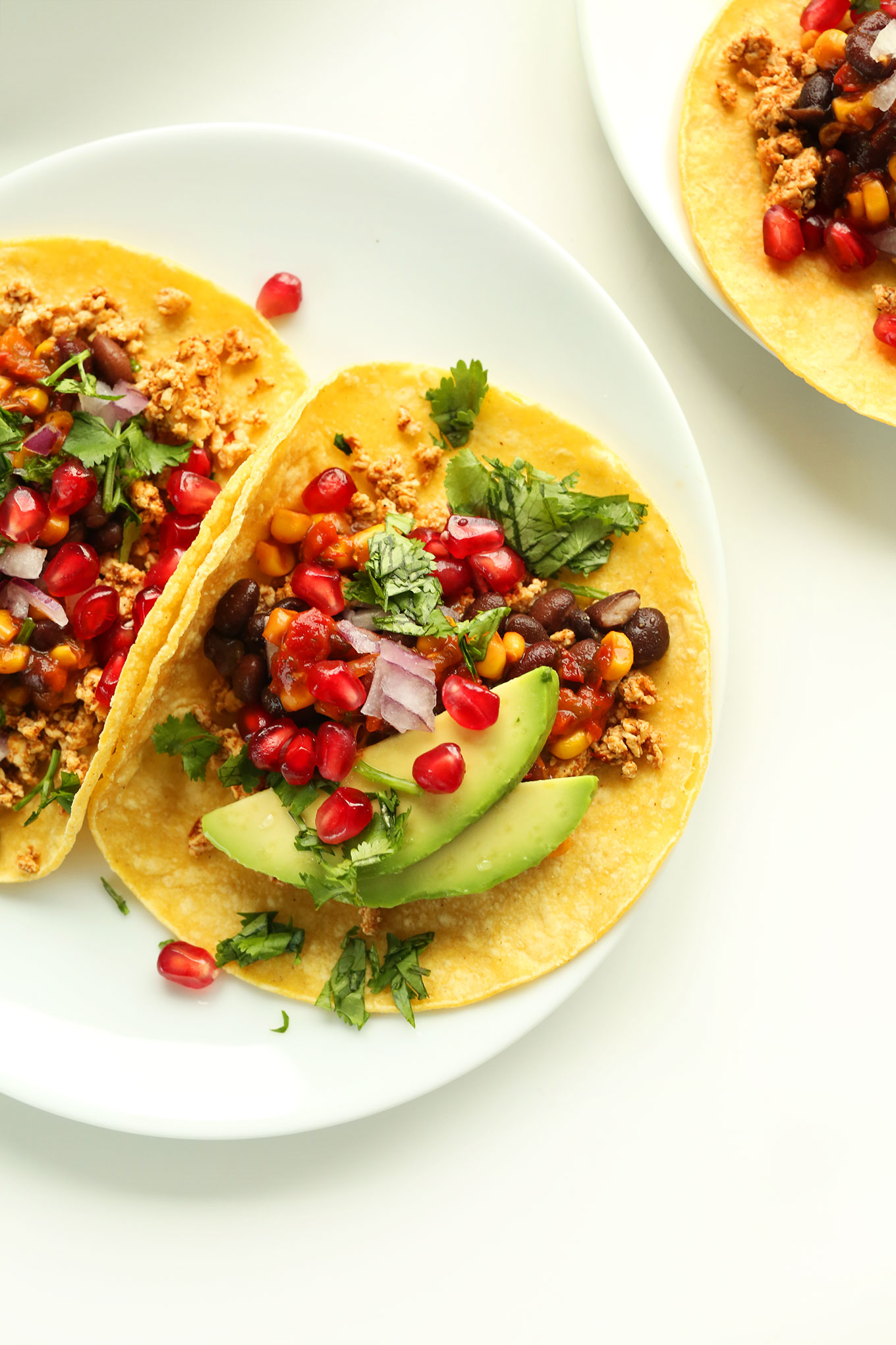 Close up shot of vegan breakfast tacos made with spicy tofu, black beans, fruit, and veggies
