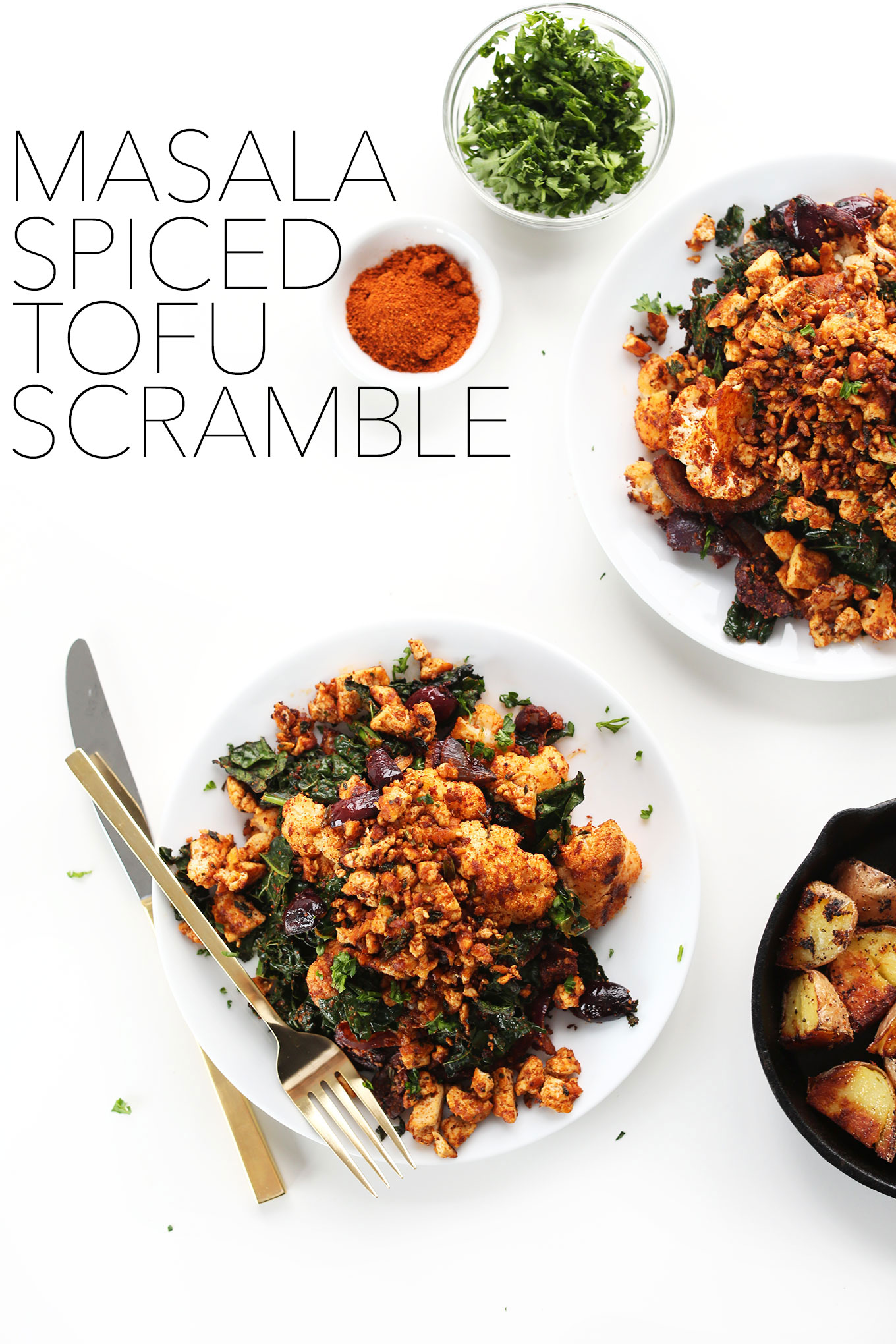 Plates of Masala Spiced Tofu Scramble with roasted veggies and breakfast potatoes