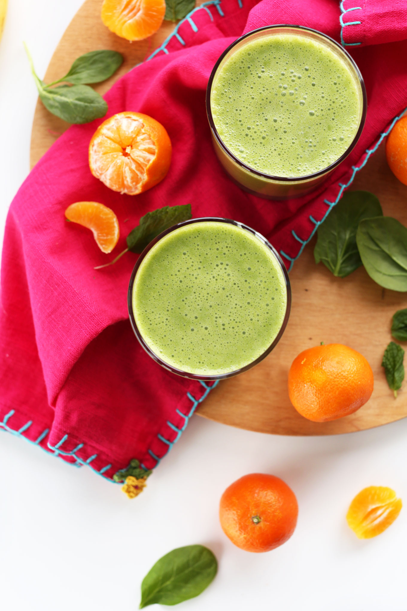 Cutting board with oranges and glasses of our Green Coconut Clementine Smoothie