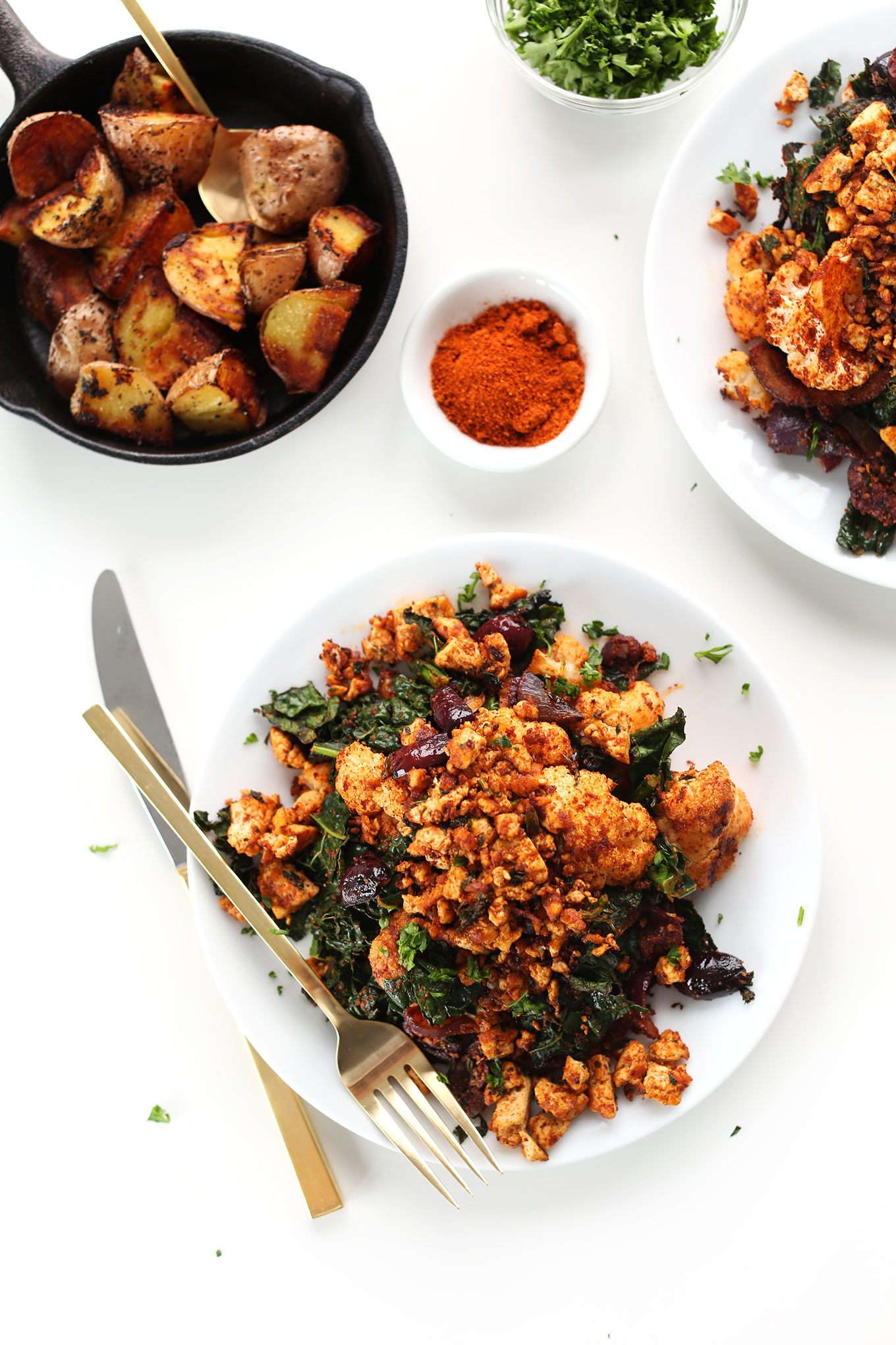 Plates of our Tofu Scramble recipe with Masala-spiced cauliflower, kale, onion, and potatoes