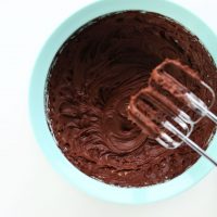 Electric mixer blades resting over a bowl of Vegan Chocolate Ganache Frosting