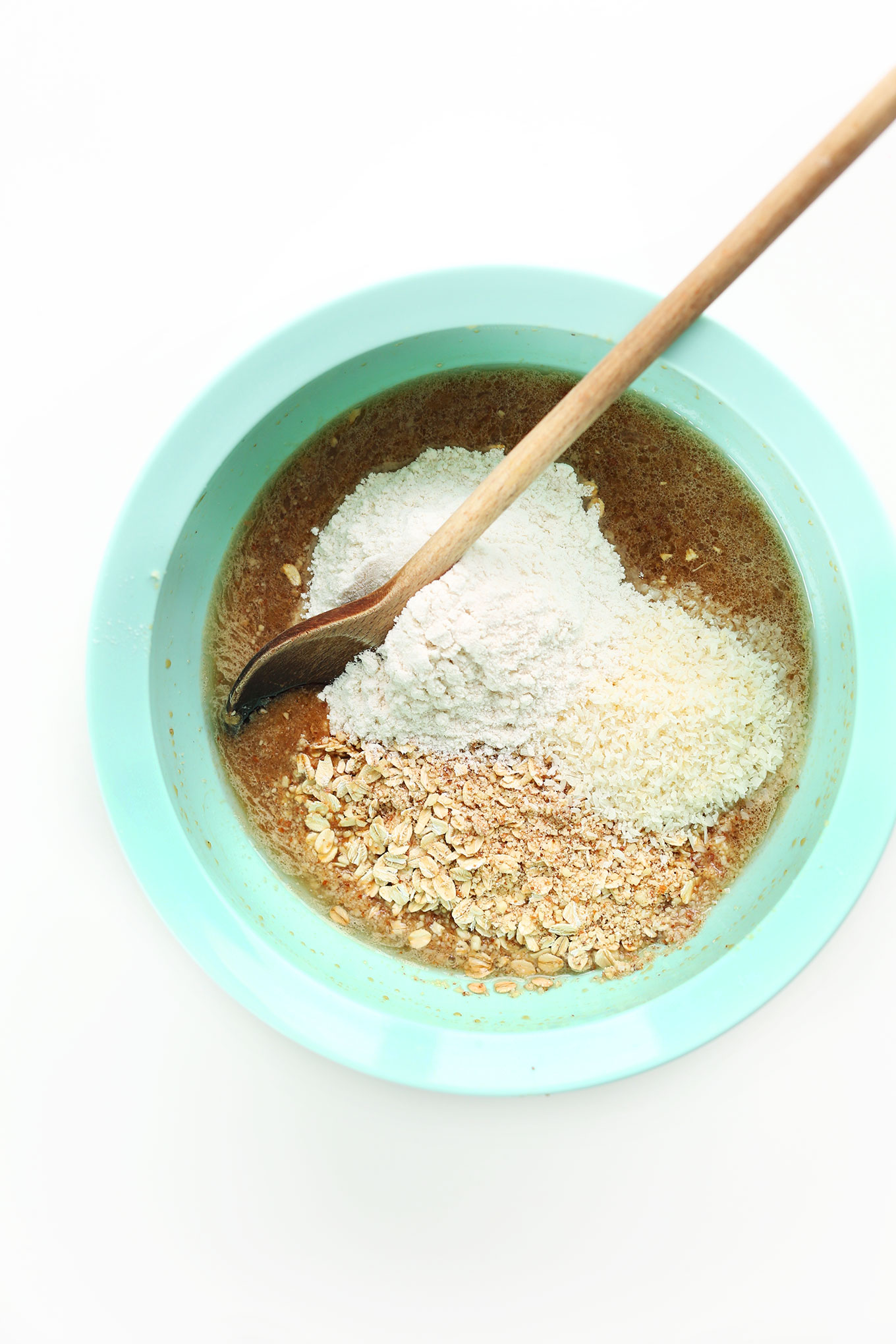 Stirring together ingredients for homemade simple Vegan Gluten-Free Berry Coconut Muffins