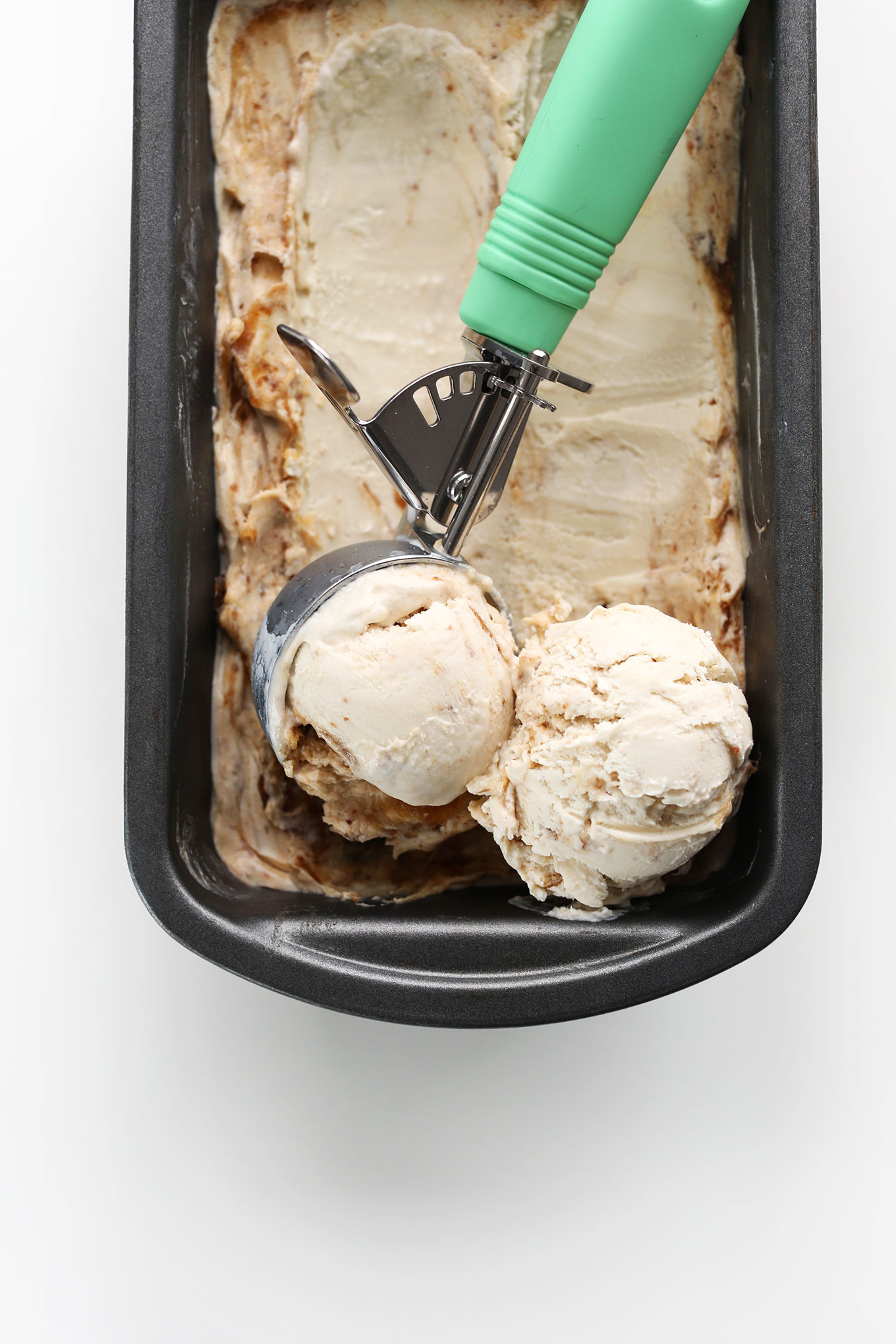 Using an ice cream scooper to grab scoops of creamy Vegan Coconut Caramel Sea Salt Ice Cream