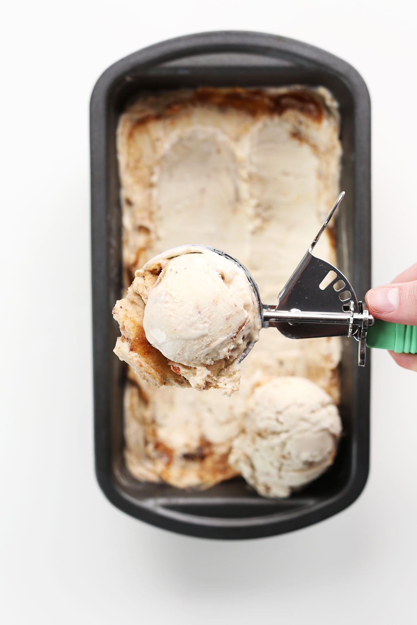 Holding up a scoop of Vegan Sea Salt Caramel Ice Cream made with dates