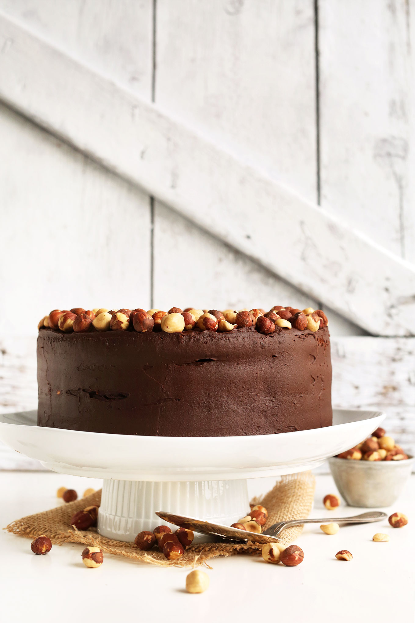 Vegan GF Chocolate Hazelnut Cake perched on a cake stand