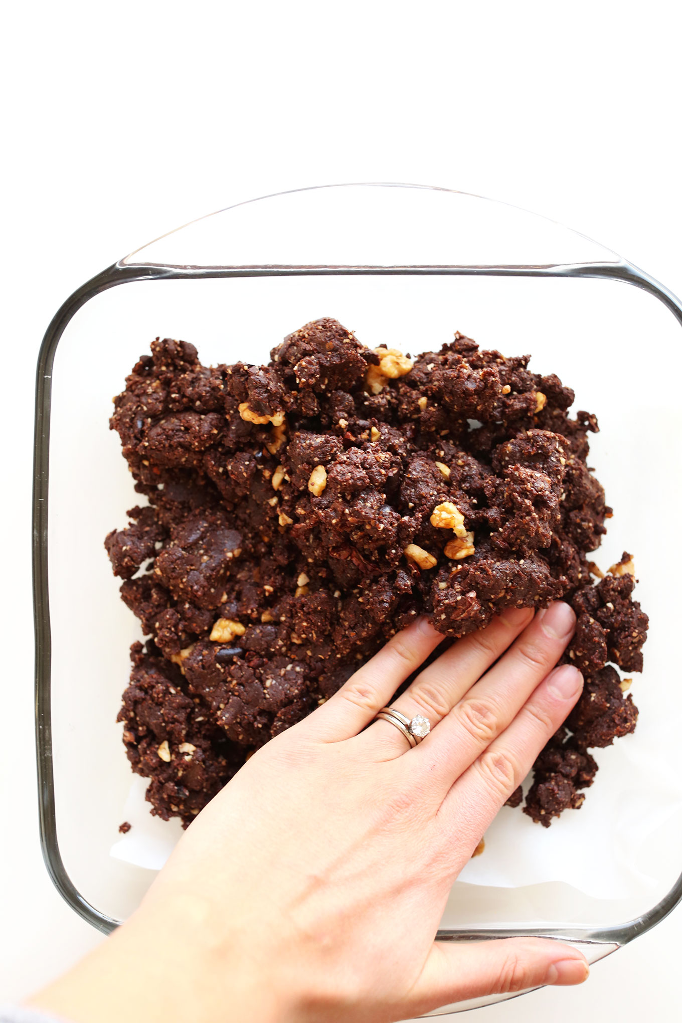 Pressing gluten-free vegan No-Bake Brownie batter into a pan