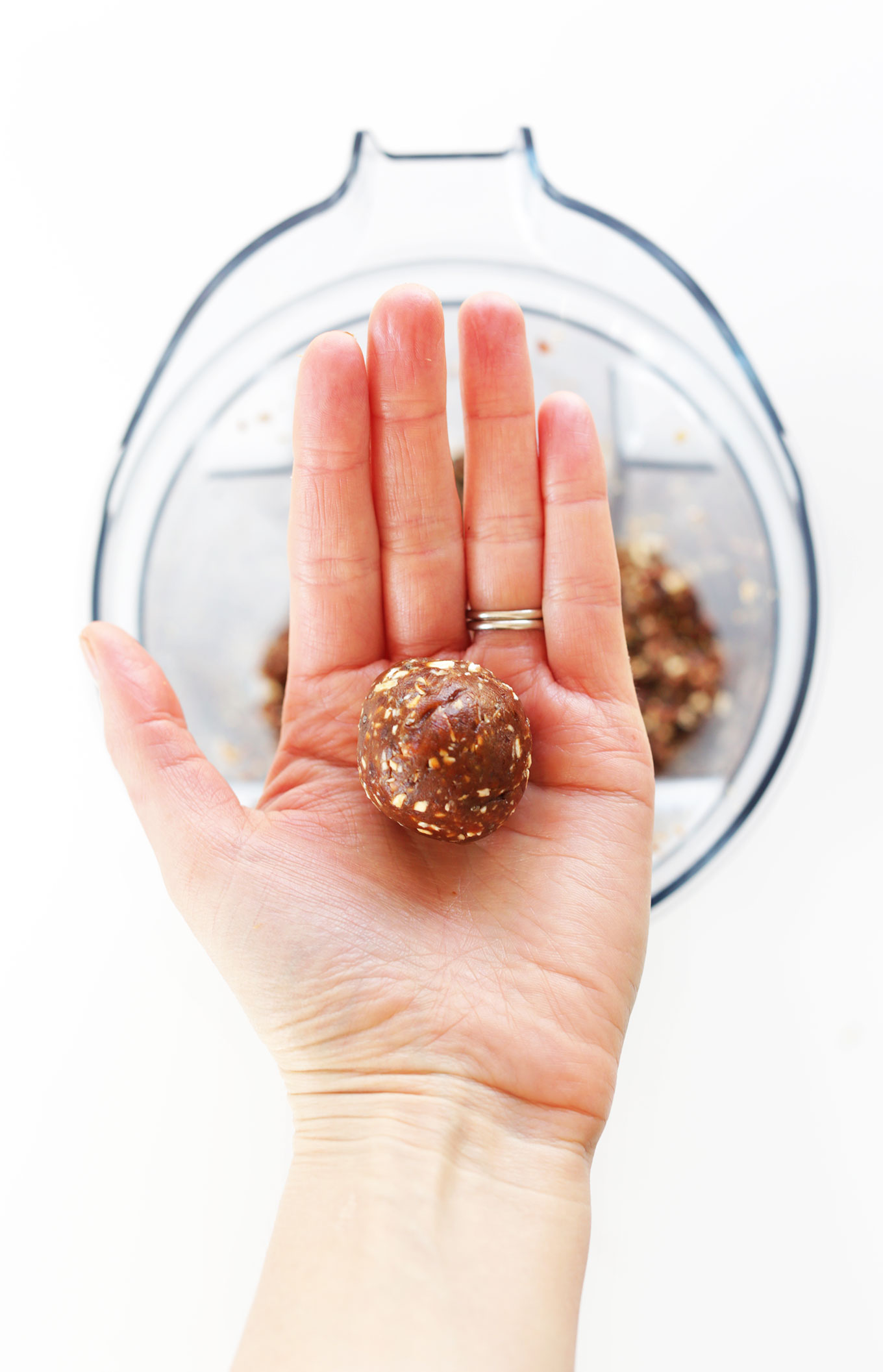 Holding up a freshly rolled Peanut Butter Cup Energy Bite for a delicious snack