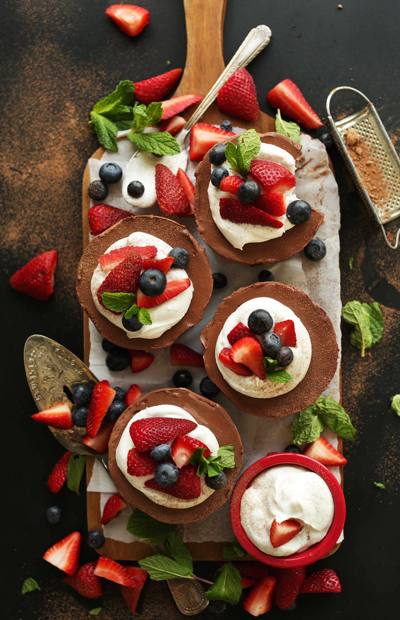 Top view of a batch of our mini Vegan Chocolate Cheesecakes topped with coconut whip and fresh berries