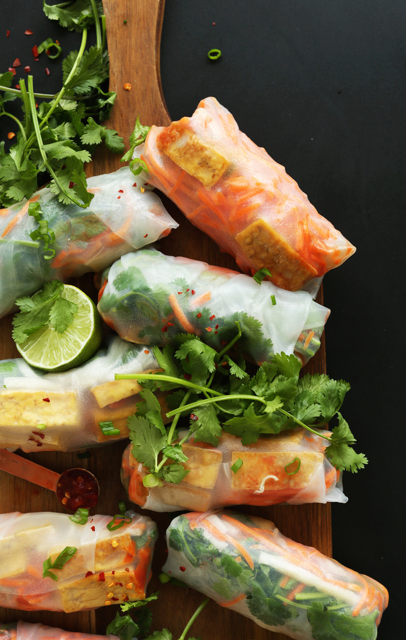 Wood cutting board with homemade vegan Bahn Mi Spring Rolls