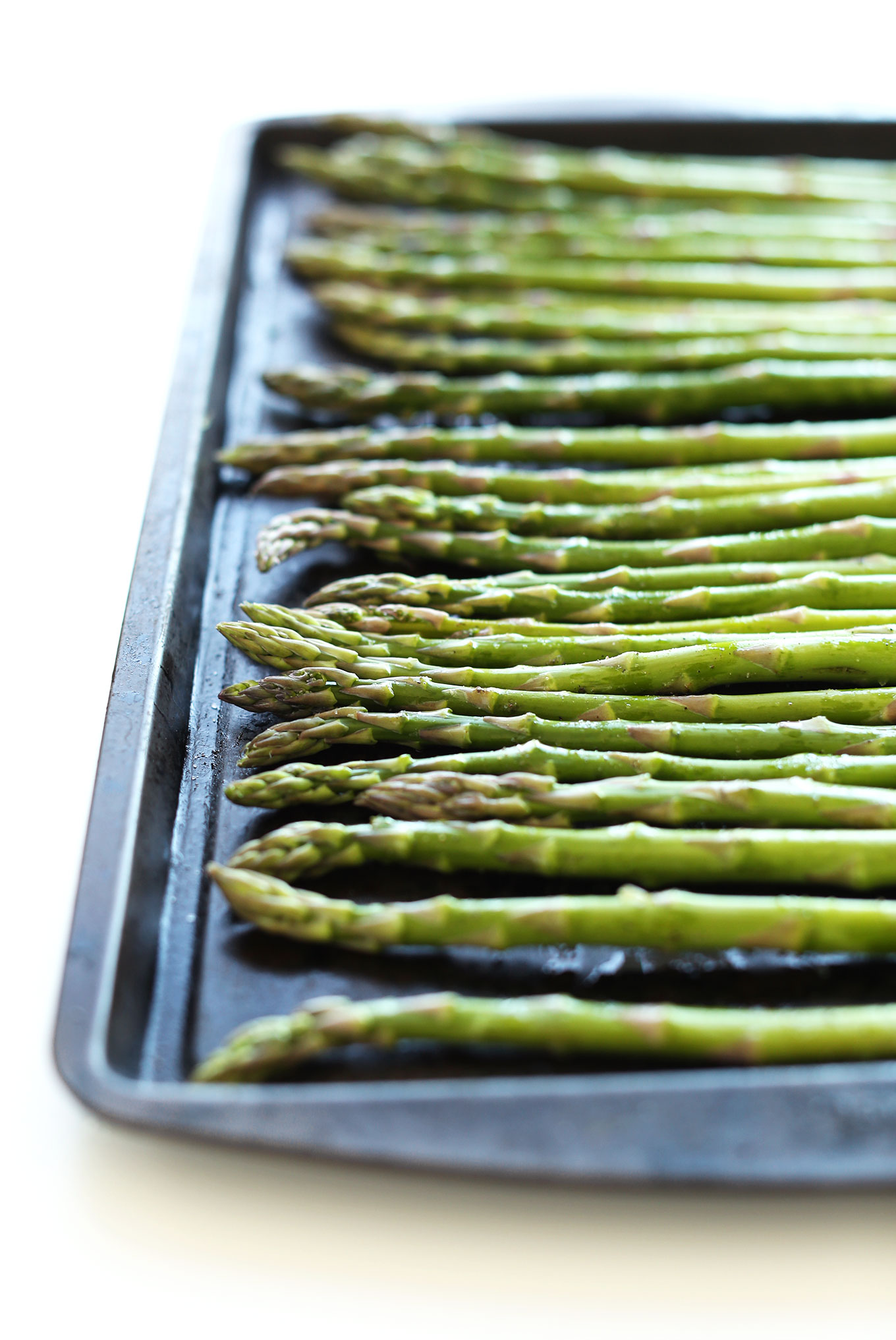 Asparagus spears on a baking sheet for making Creamy Asparagus and Pea Soup