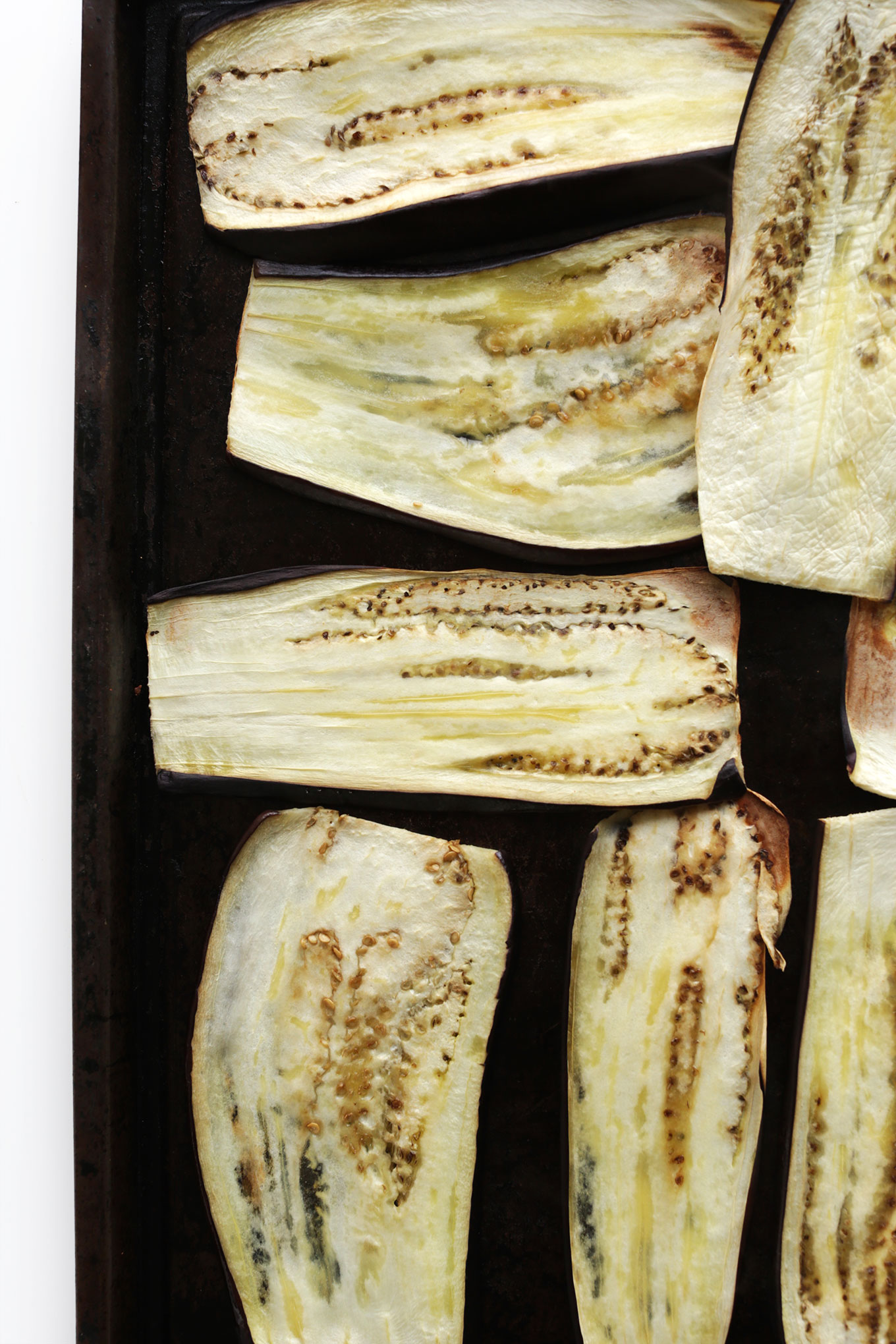 Thinly sliced eggplant on a baking sheet for making gluten-free vegan Eggplant Ricotta Roll-Ups