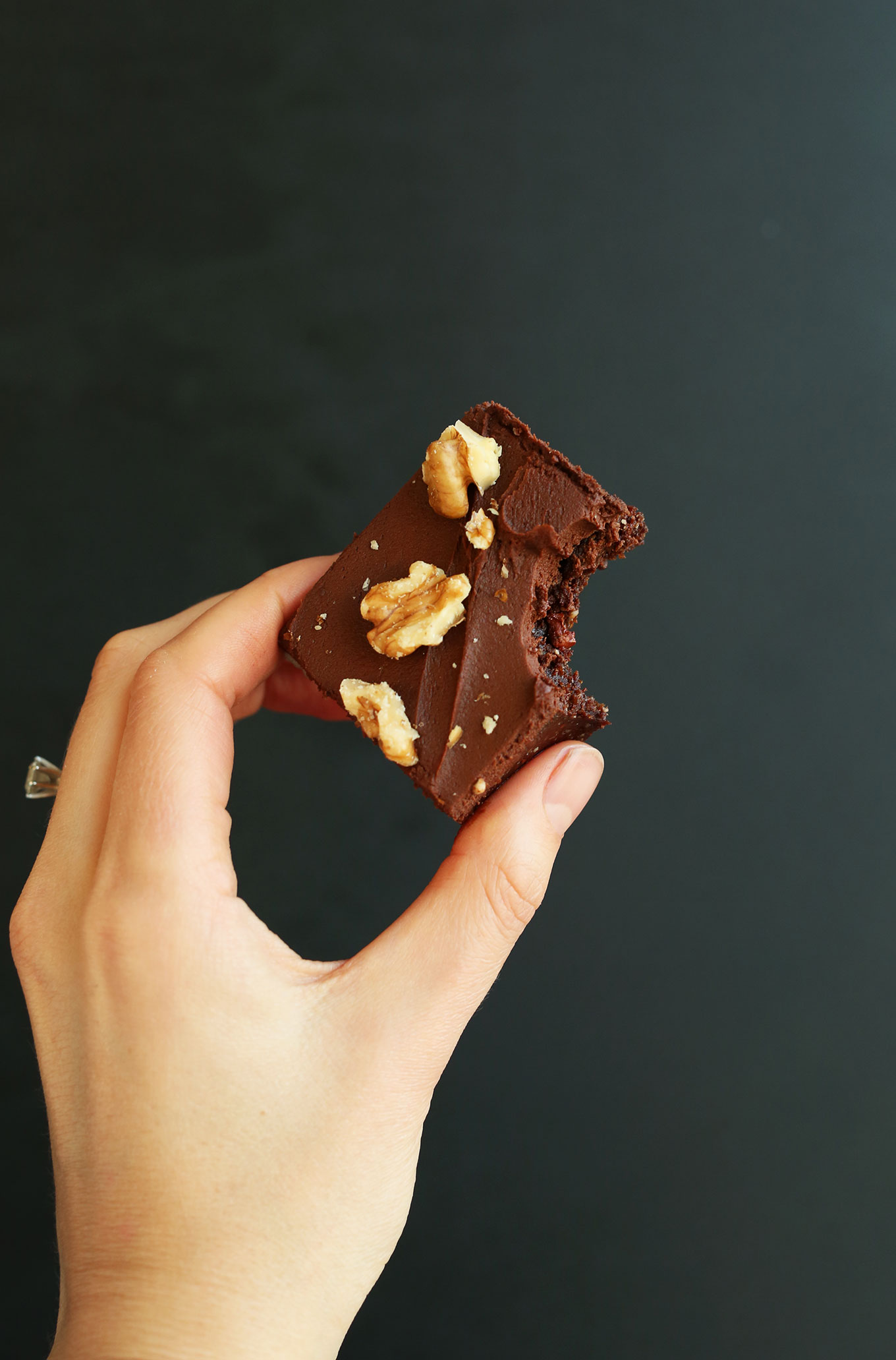 Holding up a raw gluten-free vegan brownie for a delicious dessert