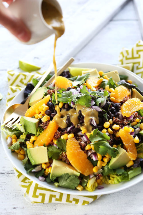 Pouring a delicious homemade vegan dressing onto Mexican Quinoa Salad