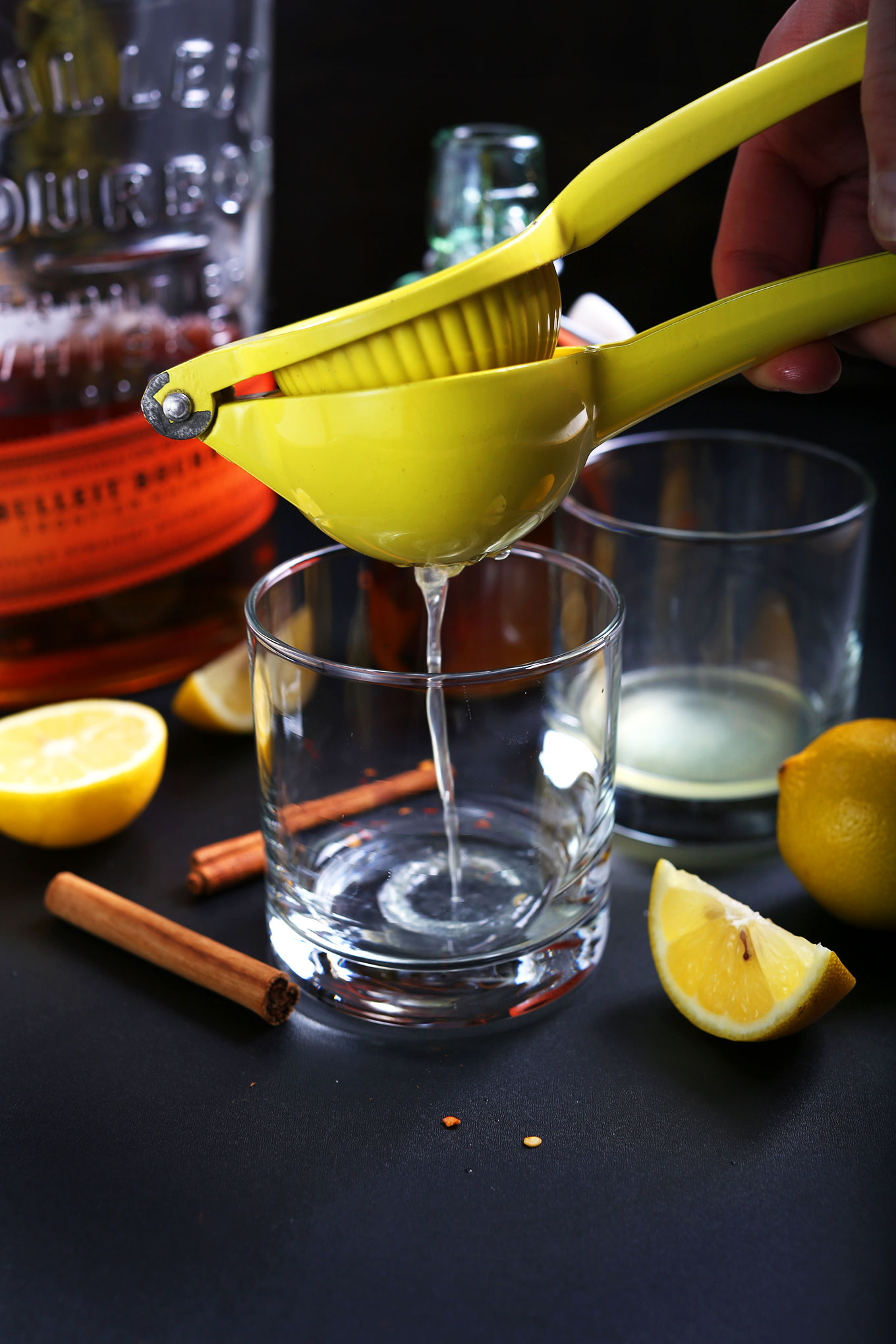 Squeezing lemon juice into glasses to make the ultimate homemade Hot Toddy
