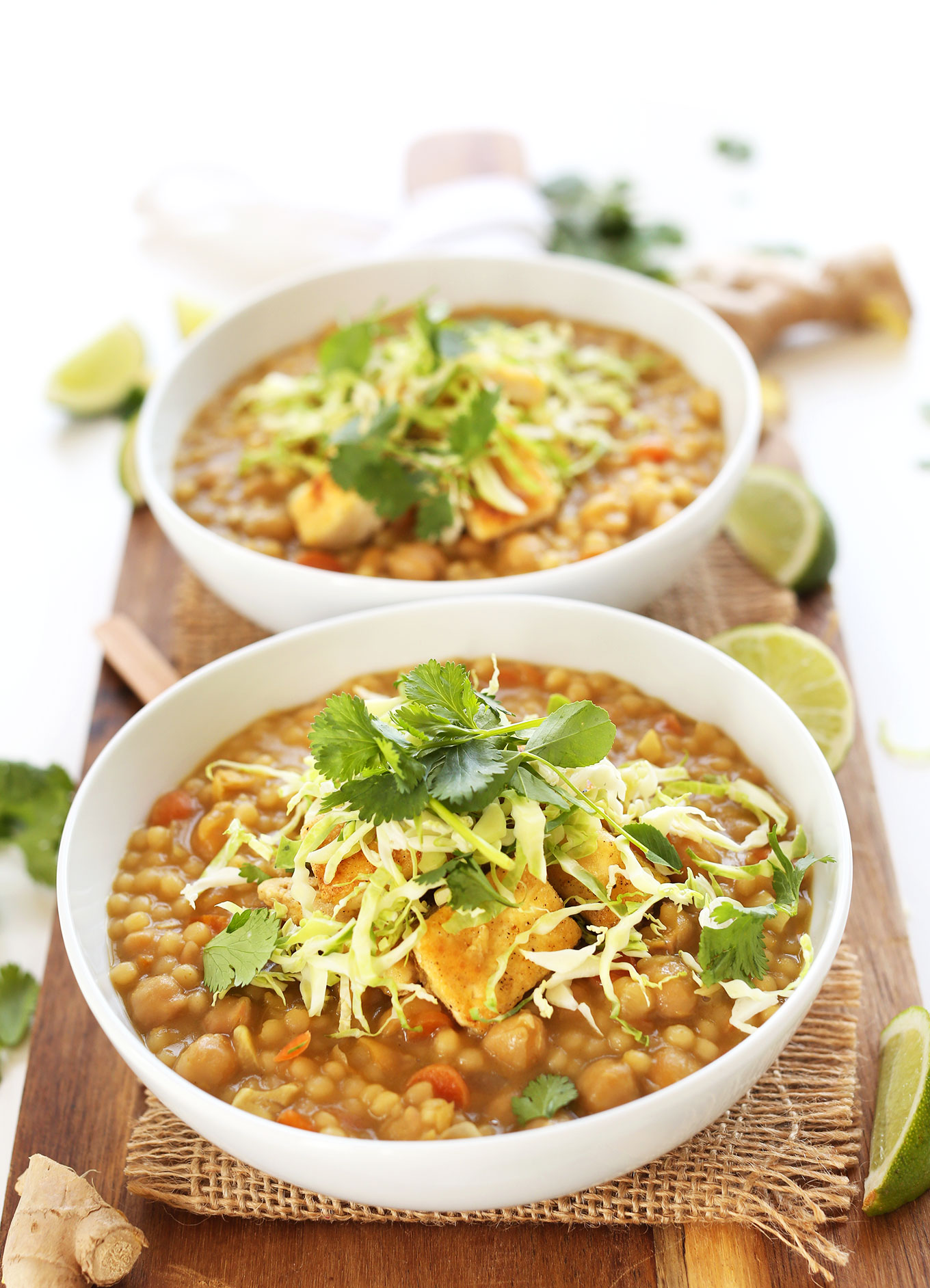 Bowls of Green Chickpea Curry with Israeli Couscous topped with fresh cabbage and cilantro