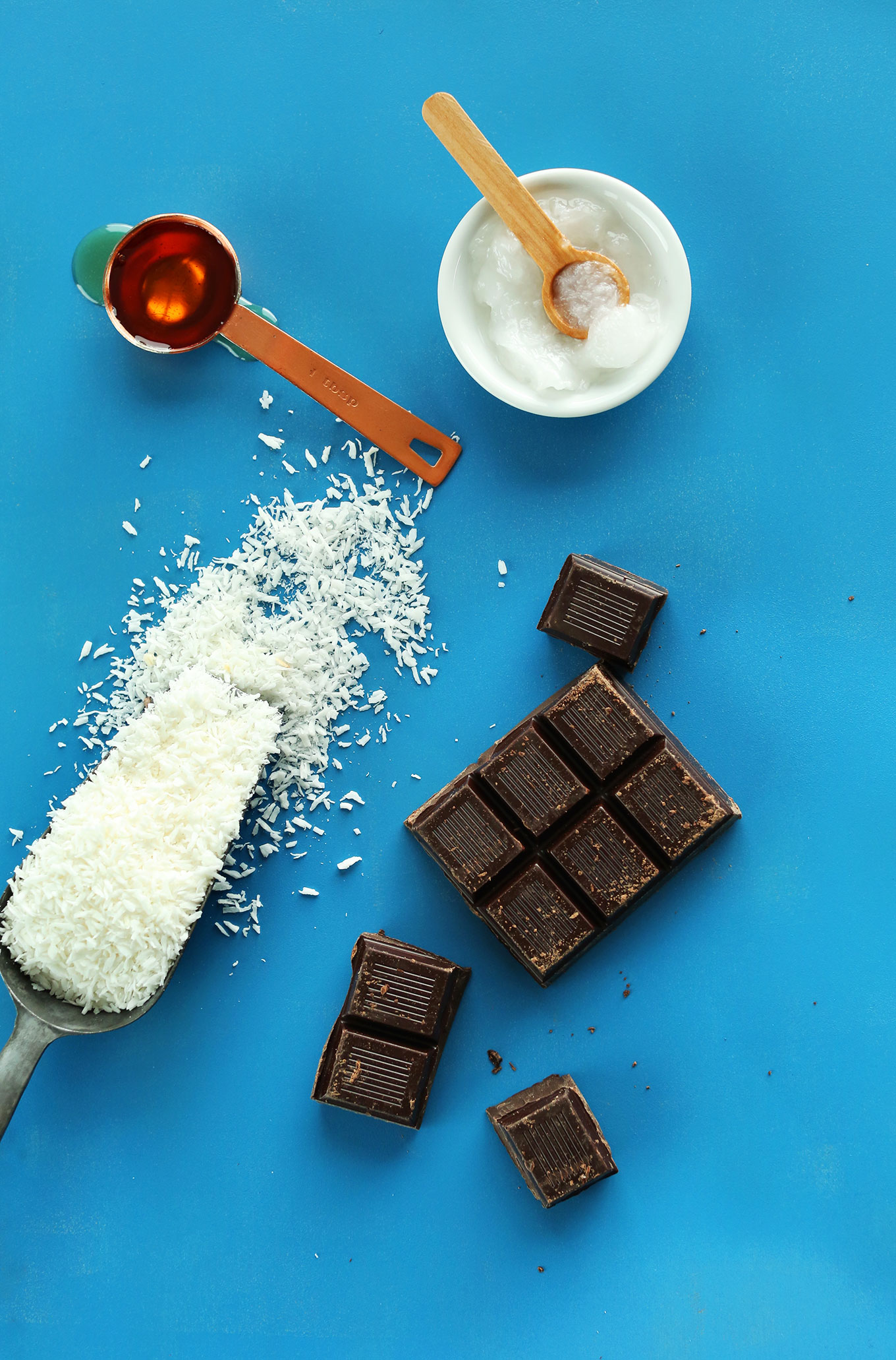 Shredded coconut, dark chocolate, coconut oil, and maple syrup for making Chocolate-Dipped Coconut Macaroons