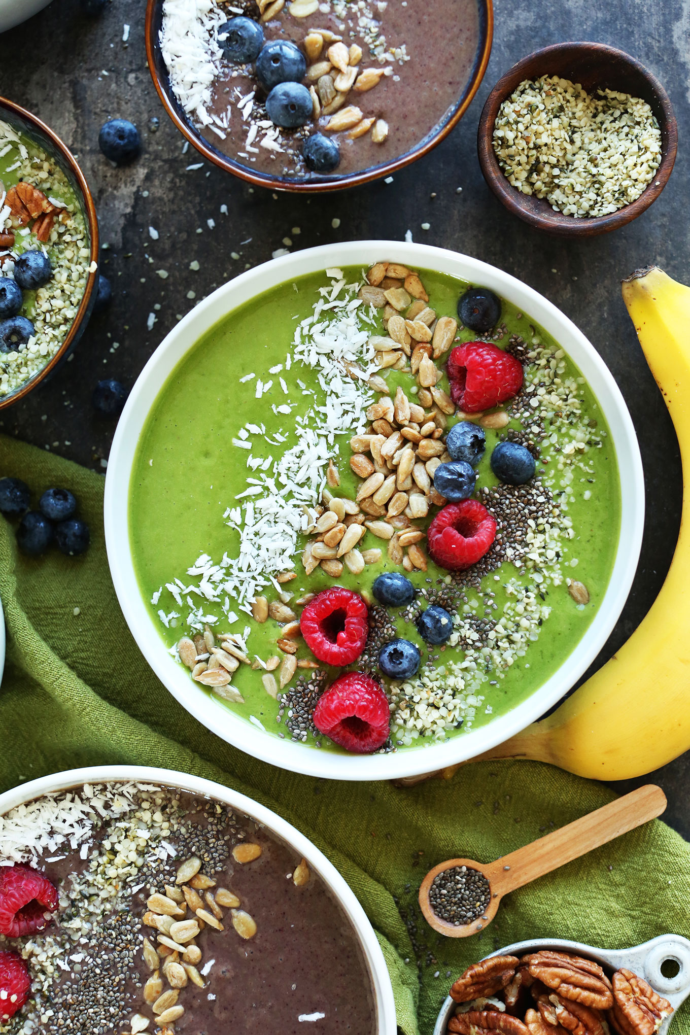 Super Green Smoothie Bowl topped with shredded coconut, sunflower seeds, hemp seeds, chia seeds, and fresh berries