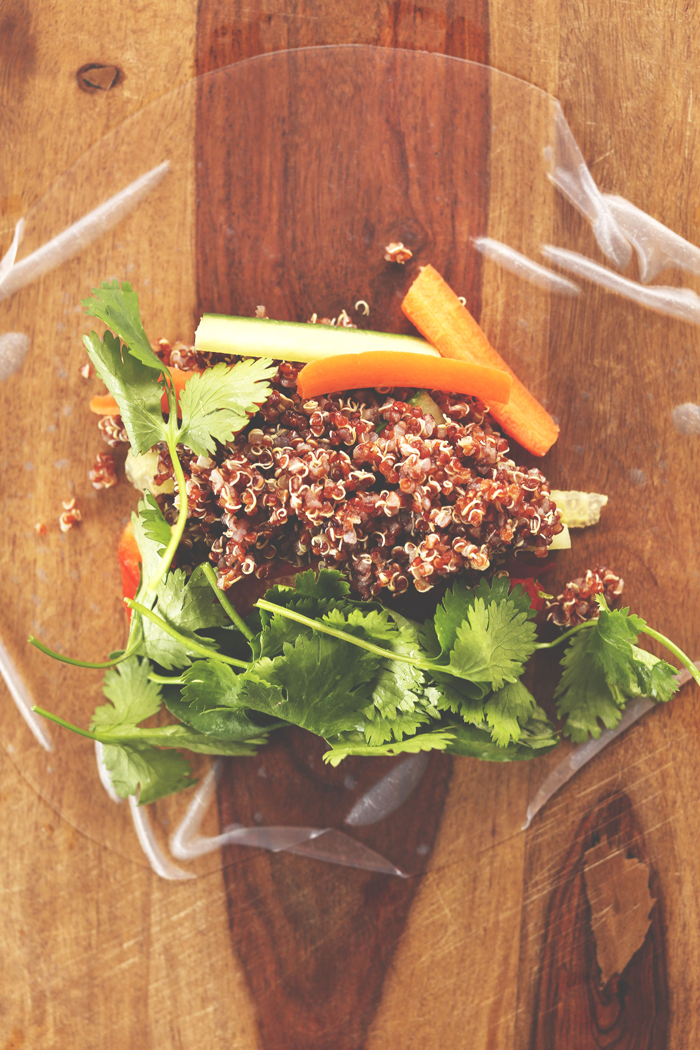 Wood cutting board with a rice paper wrapper and filling ingredients for homemade healthy Spring Rolls