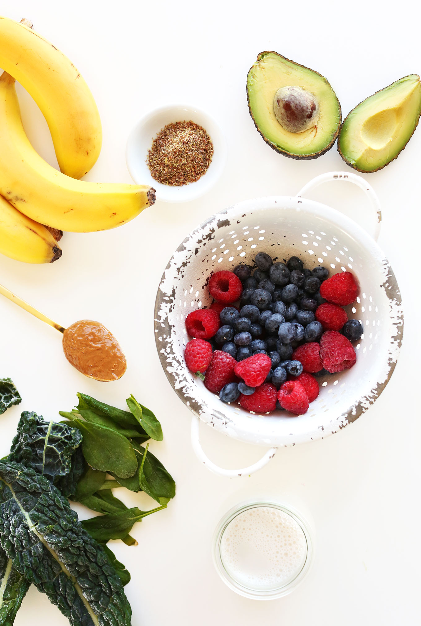 Avocado, flax seed meal, bananas, peanut butter, greens, almond milk, and berries for making Green Smoothie Bowls