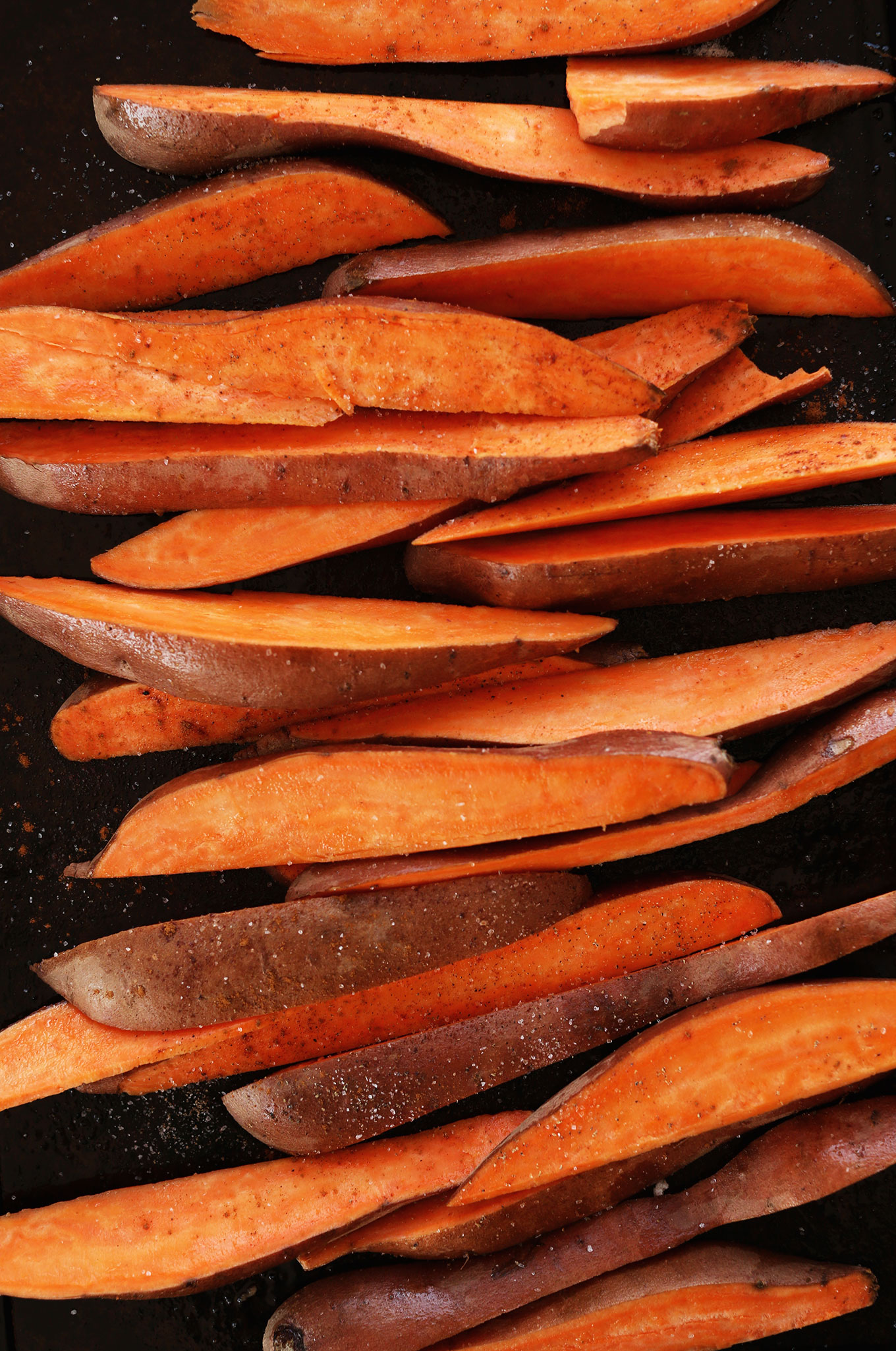 Baking sheet with Sweet Potato Wedges topped with salt and spices