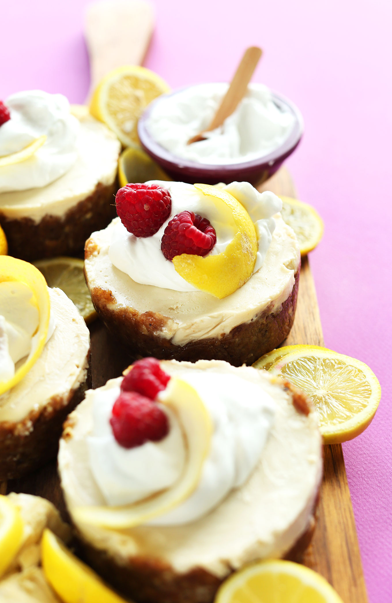 Round mini White Chocolate Lemon Cheesecakes on a cutting board