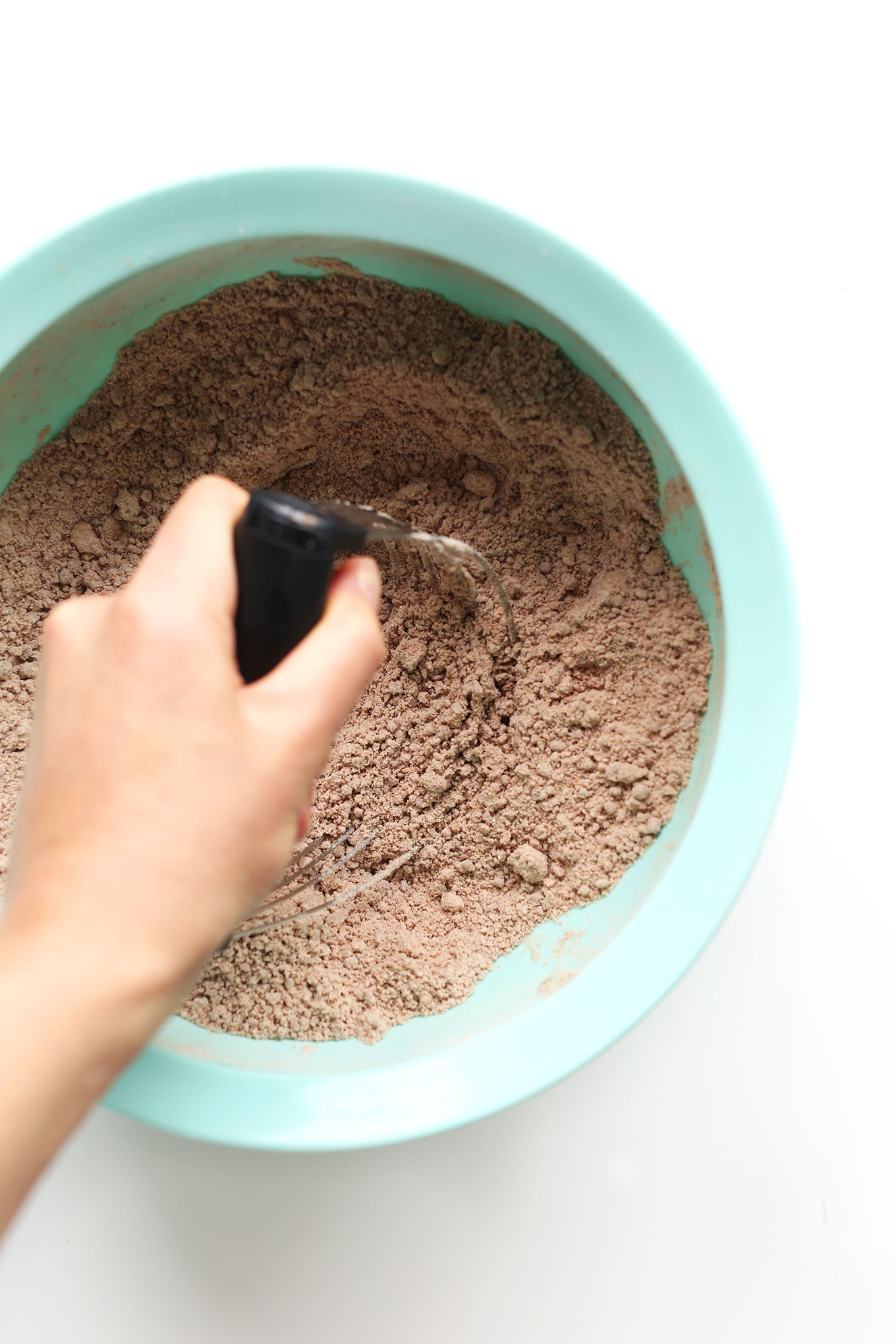 Using a pastry cutter to cut coconut oil into dry ingredients