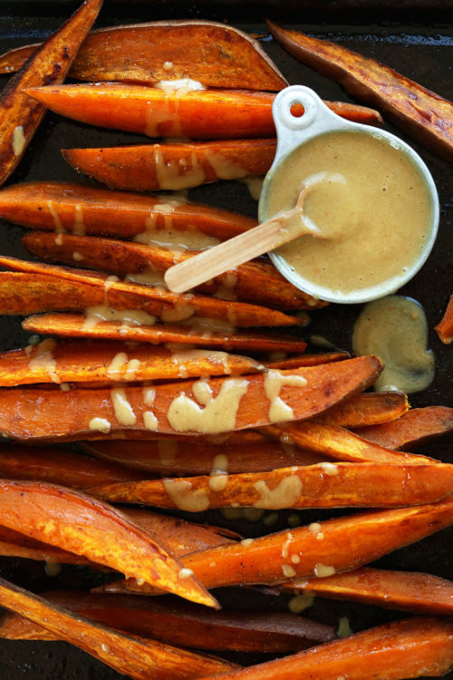 Baking sheet of Sweet Potato Wedges with Vegan Honey Mustard Dipping Sauce