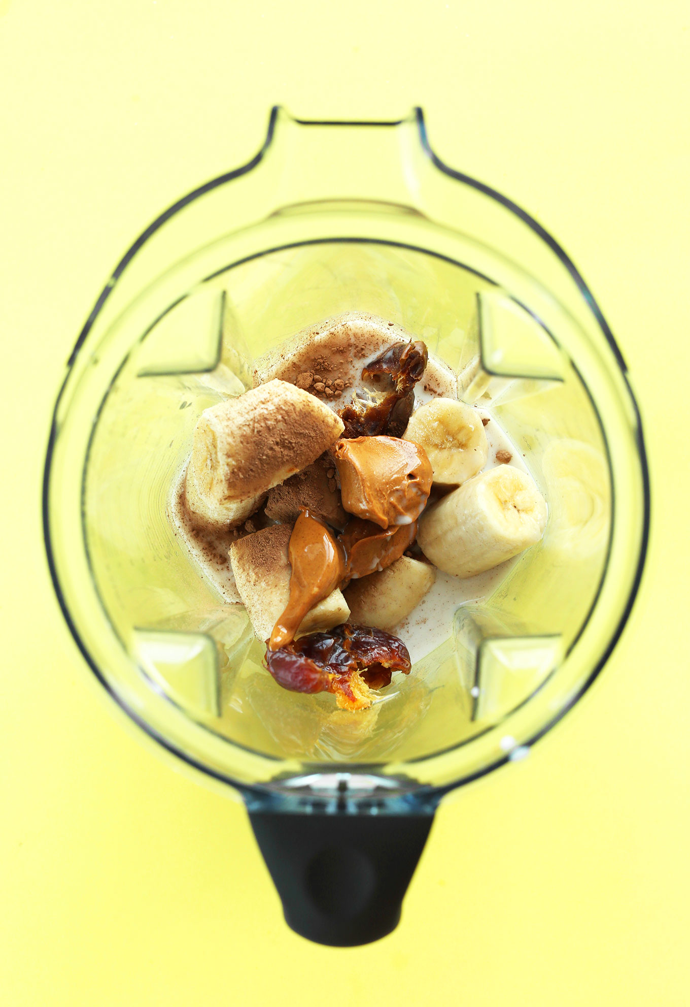 Blender with ingredients for making a creamy homemade vegan Peanut Butter Banana Milkshake