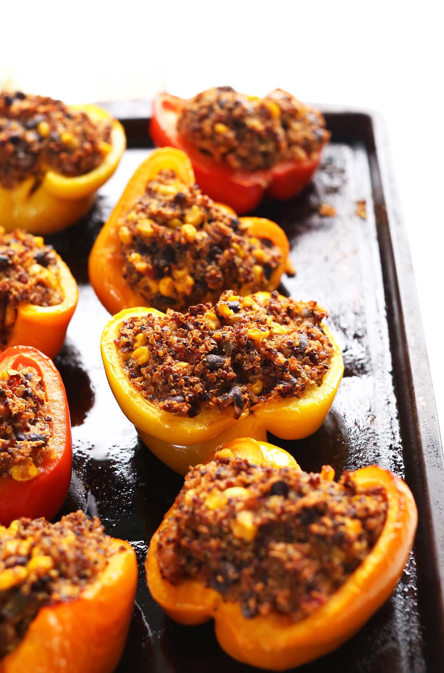 Baking sheet filled with protein-rich vegan Spanish Quinoa Stuffed Peppers